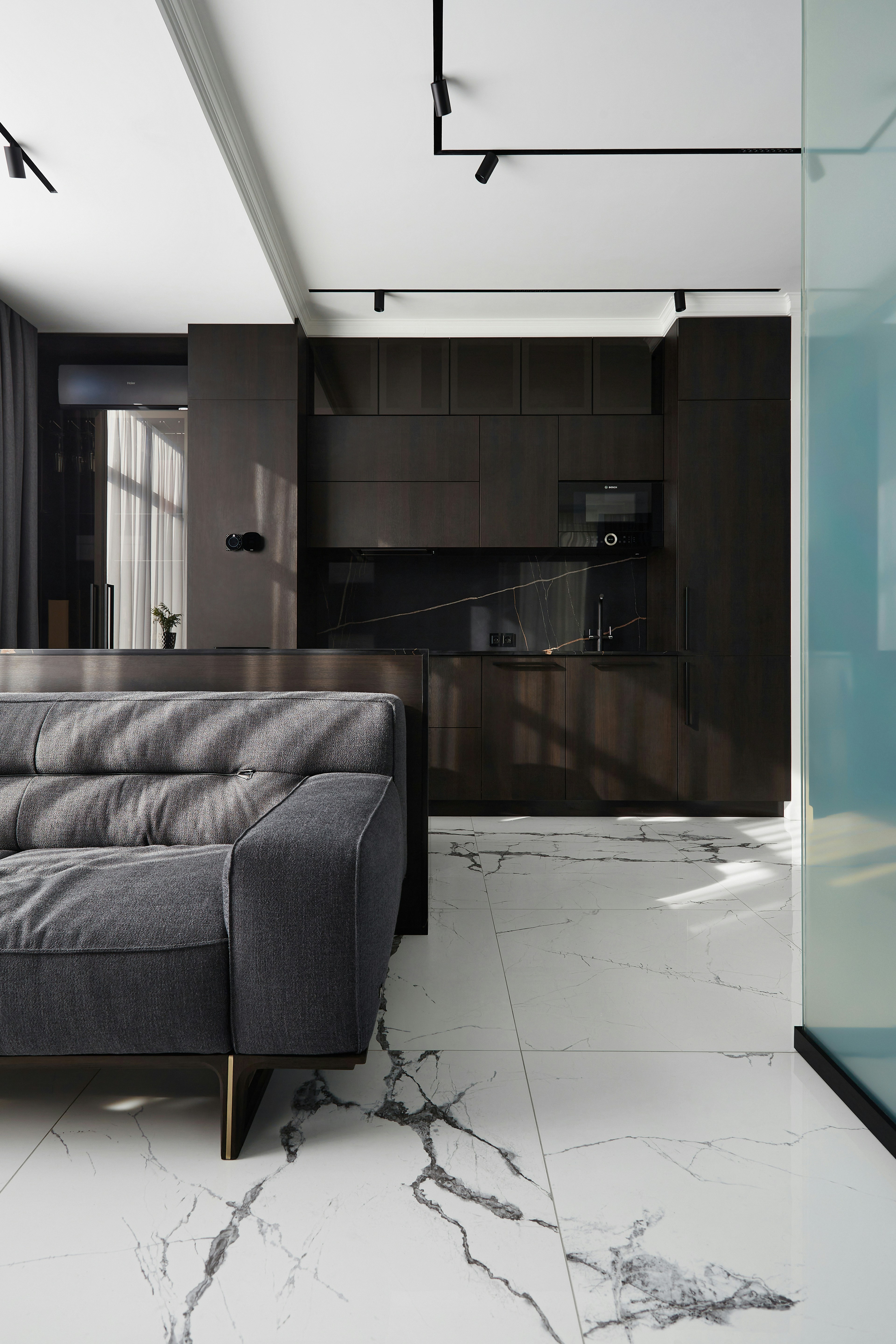 Modern living room with dark kitchen and marble floor