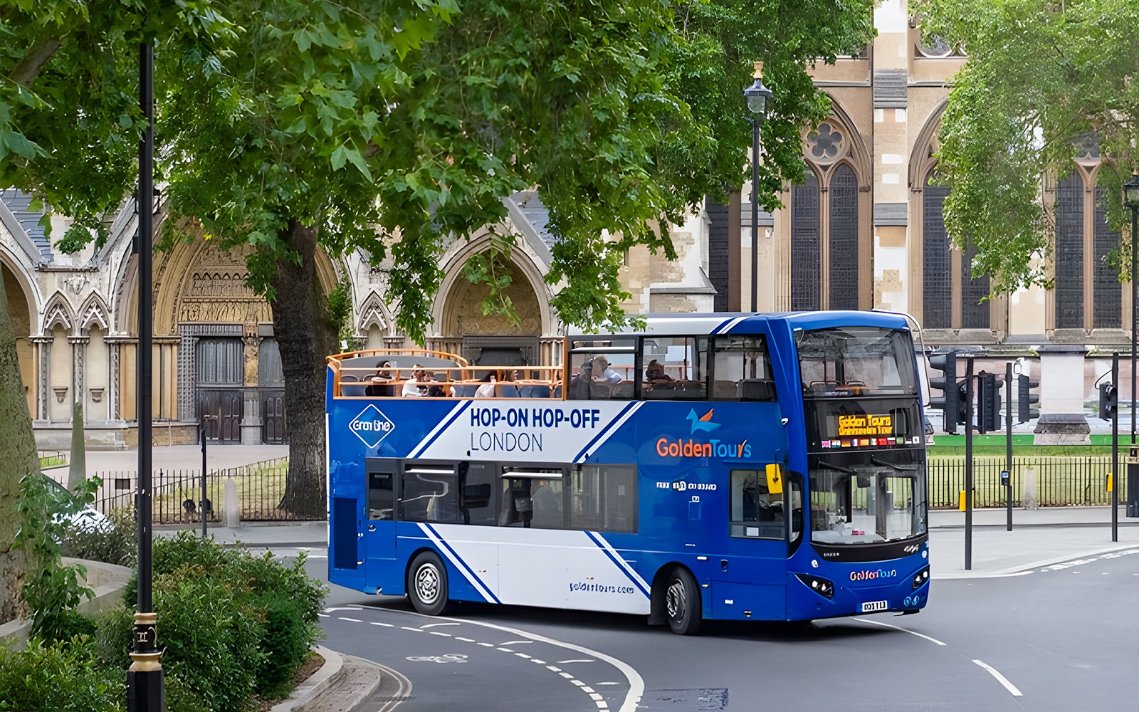 London hop-on hop-off bus passing by Big Ben and the Houses of Parliament.
