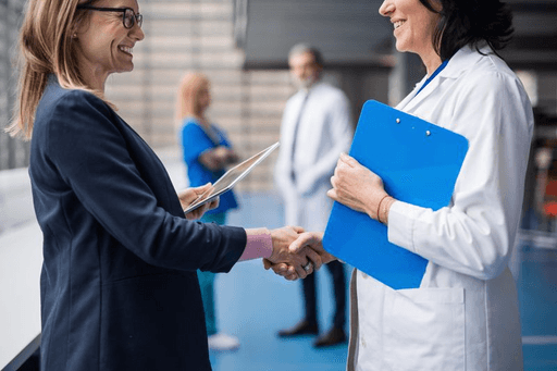 A doctor and a sales representative shake hands