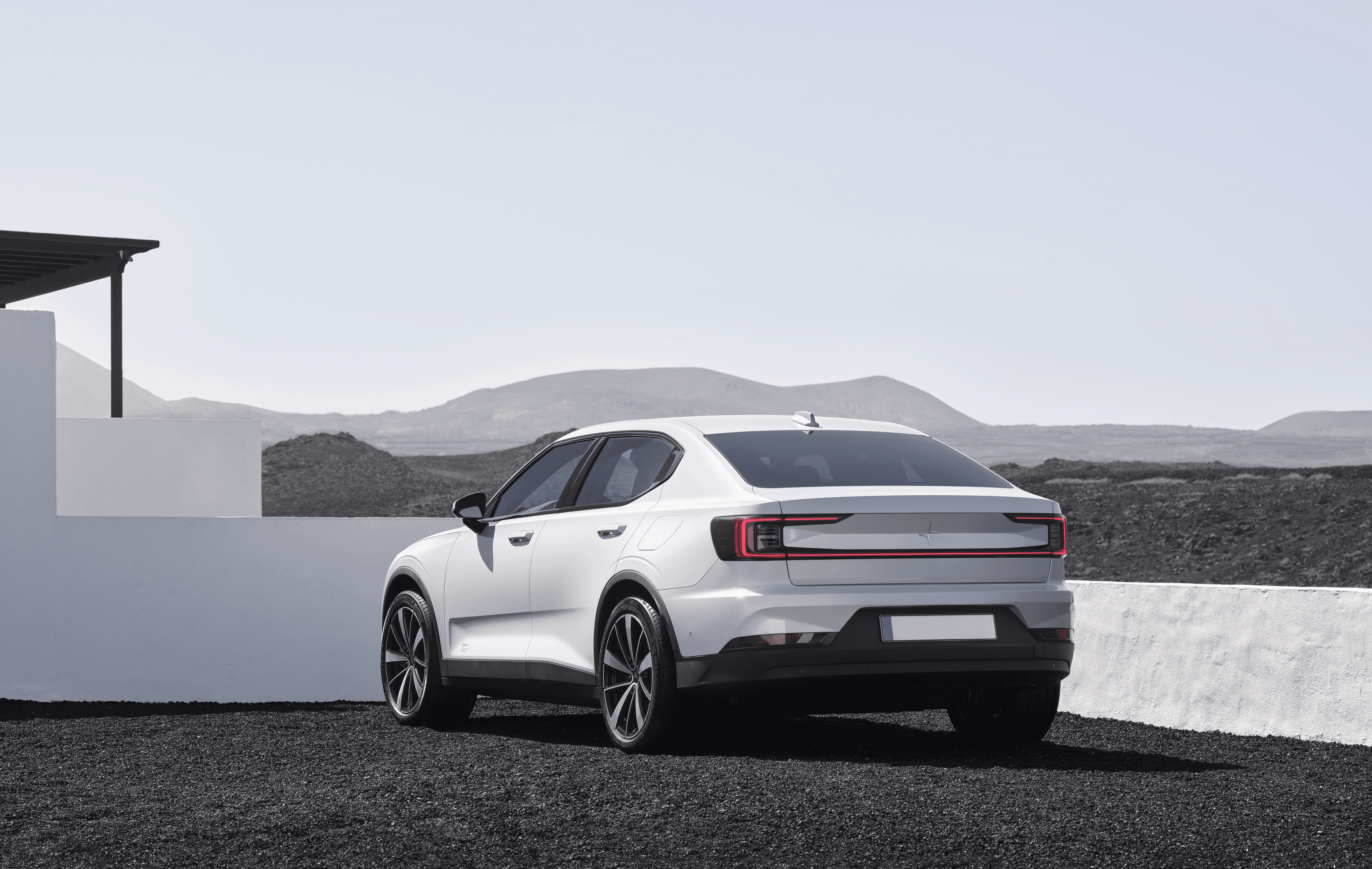 Polestar 2 blanche vue de trois quarts arrière dans un paysage minéral
