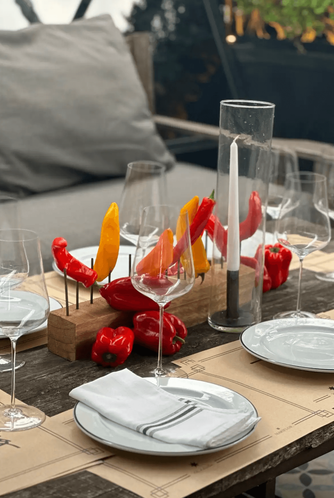 Centro de mesa expresivo con ajíes picantes rojos y amarillos ensartados en pinchos de madera sobre mesa de madera rústica.