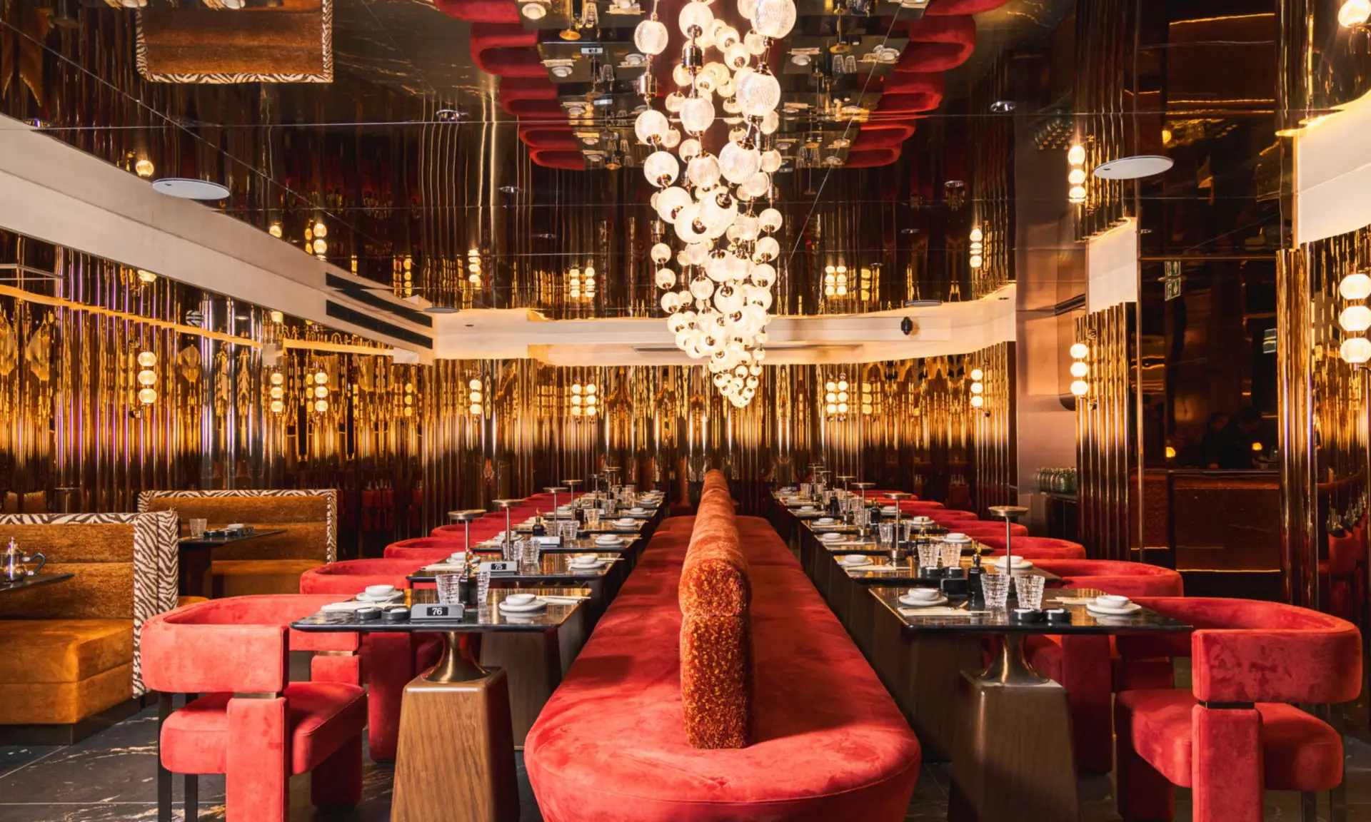 Sushi Club Porte Maillot 大厅:发光球体瀑布吊灯、红丝绒长椅与铜色镜面