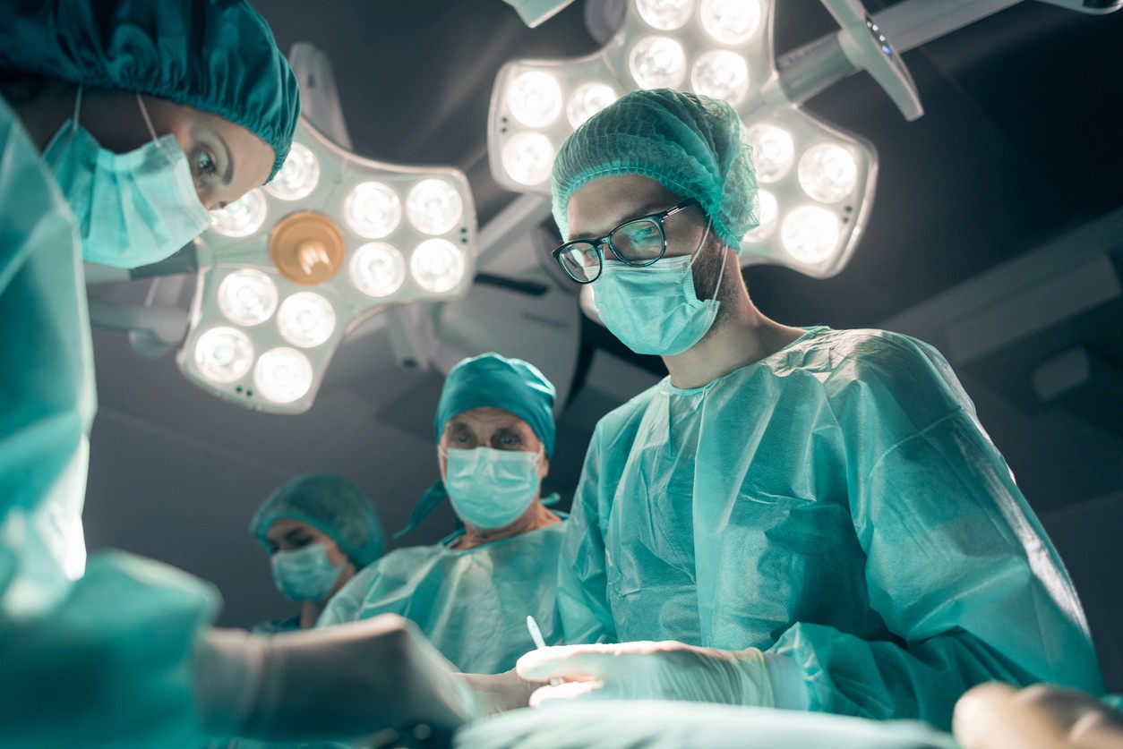 A group of doctors circled around a patient in an operating room