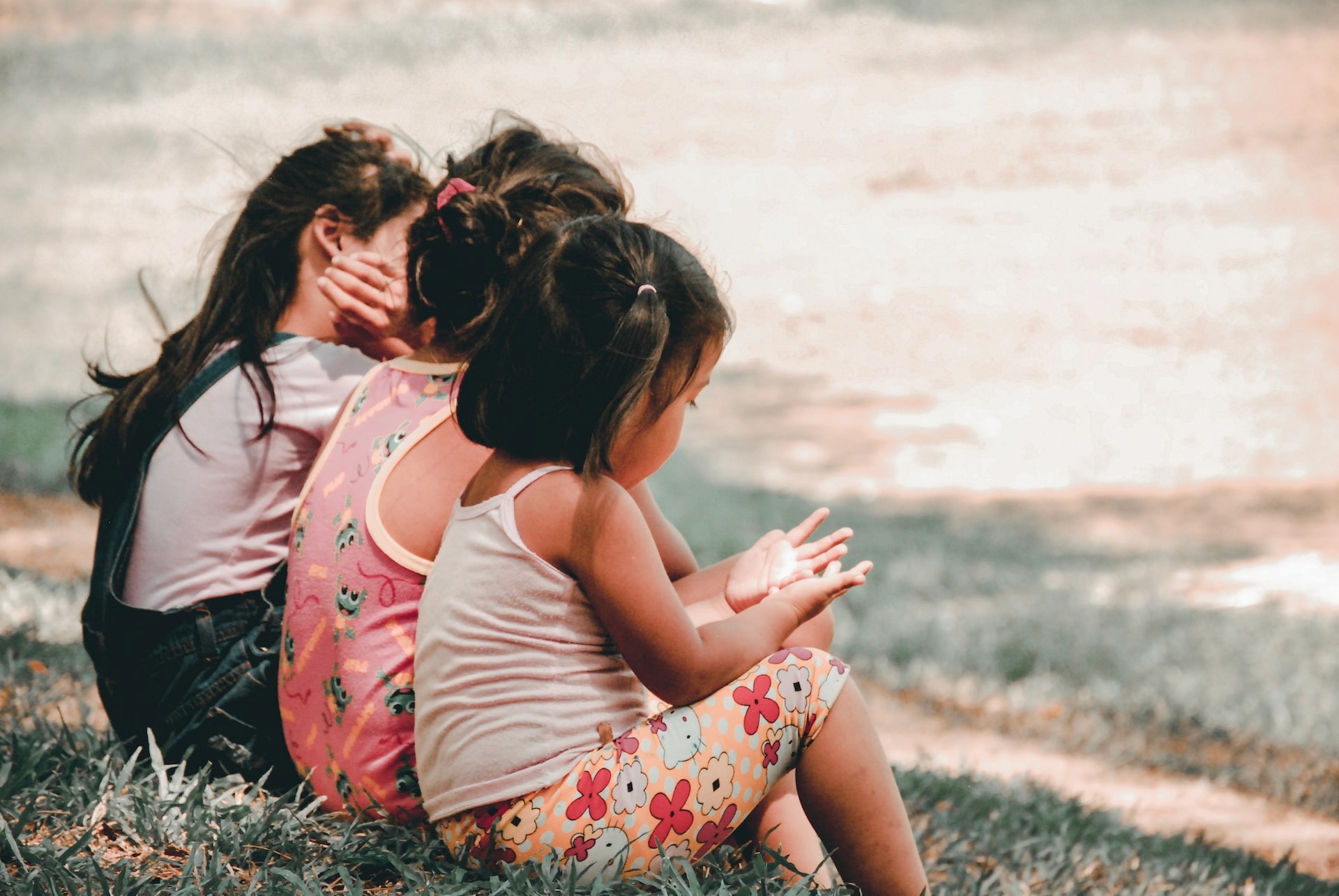 A shot of three kids together sitting on a coast