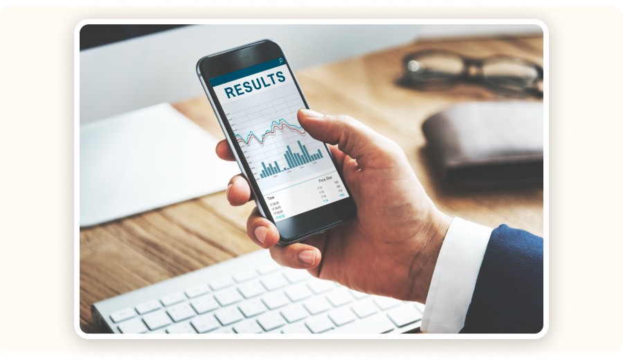 Person holding smartphone displaying analytics results with charts and performance metrics