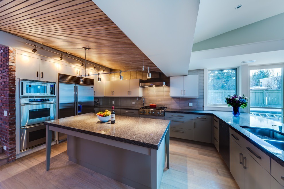 Image of Modern kitchen design with island, stainless steel appliances, and layout by KHD Homes design-build construction team.