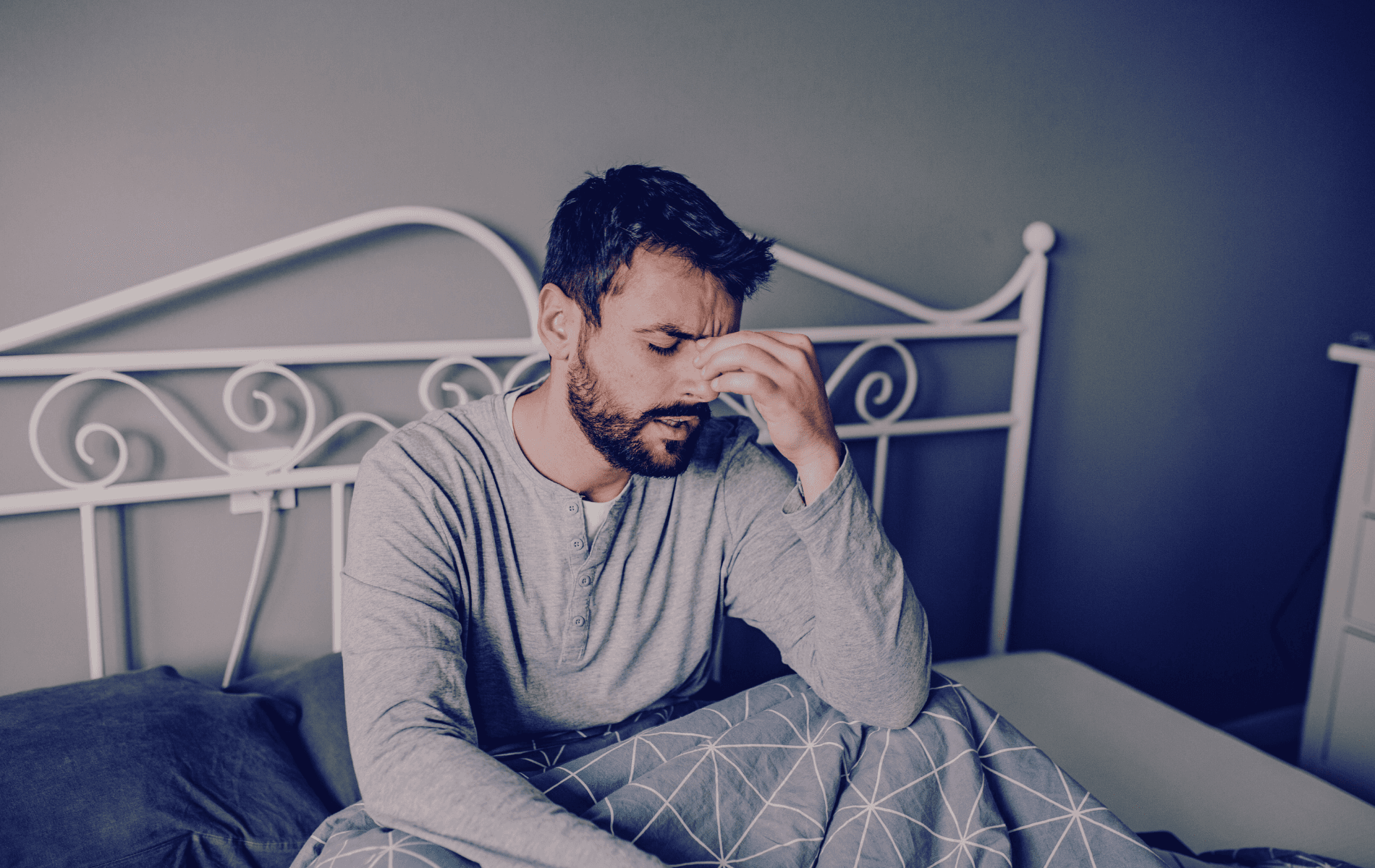 Persona con síntomas de resaca hidratándose con un vaso de agua.