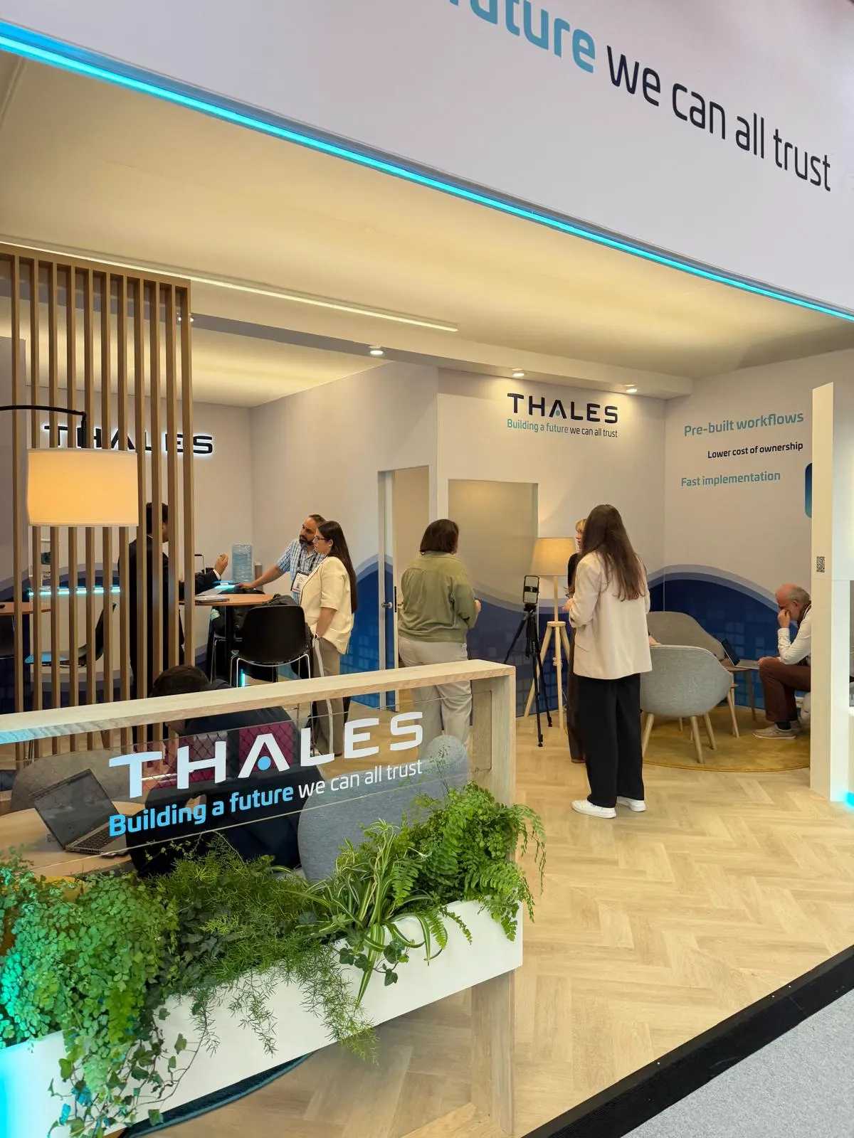 Stand Thales conçu et réalisé par Expace au Money 20/20 Europe Amsterdam – espace sur-mesure avec lounge cosy, claustras bois, jardinières végétalisées et signature « Building a future we can all trust ».