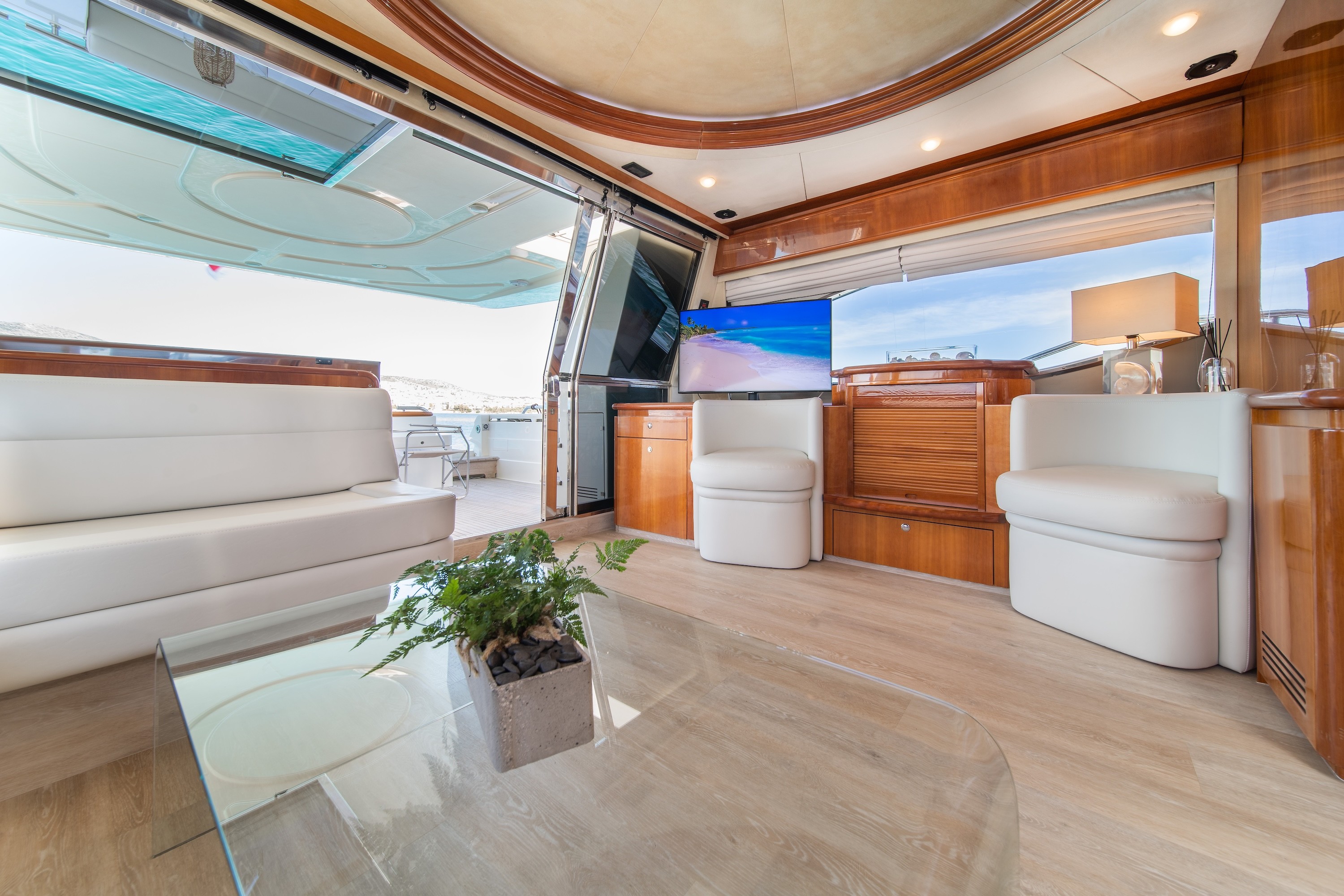 White Rock 36 speedboat with captain at helm cruising calm blue waters near Paros coastline with hills in background.