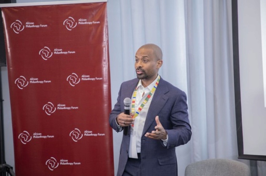 Hosh speaking with a microphone at an African Philanthropy Forum event