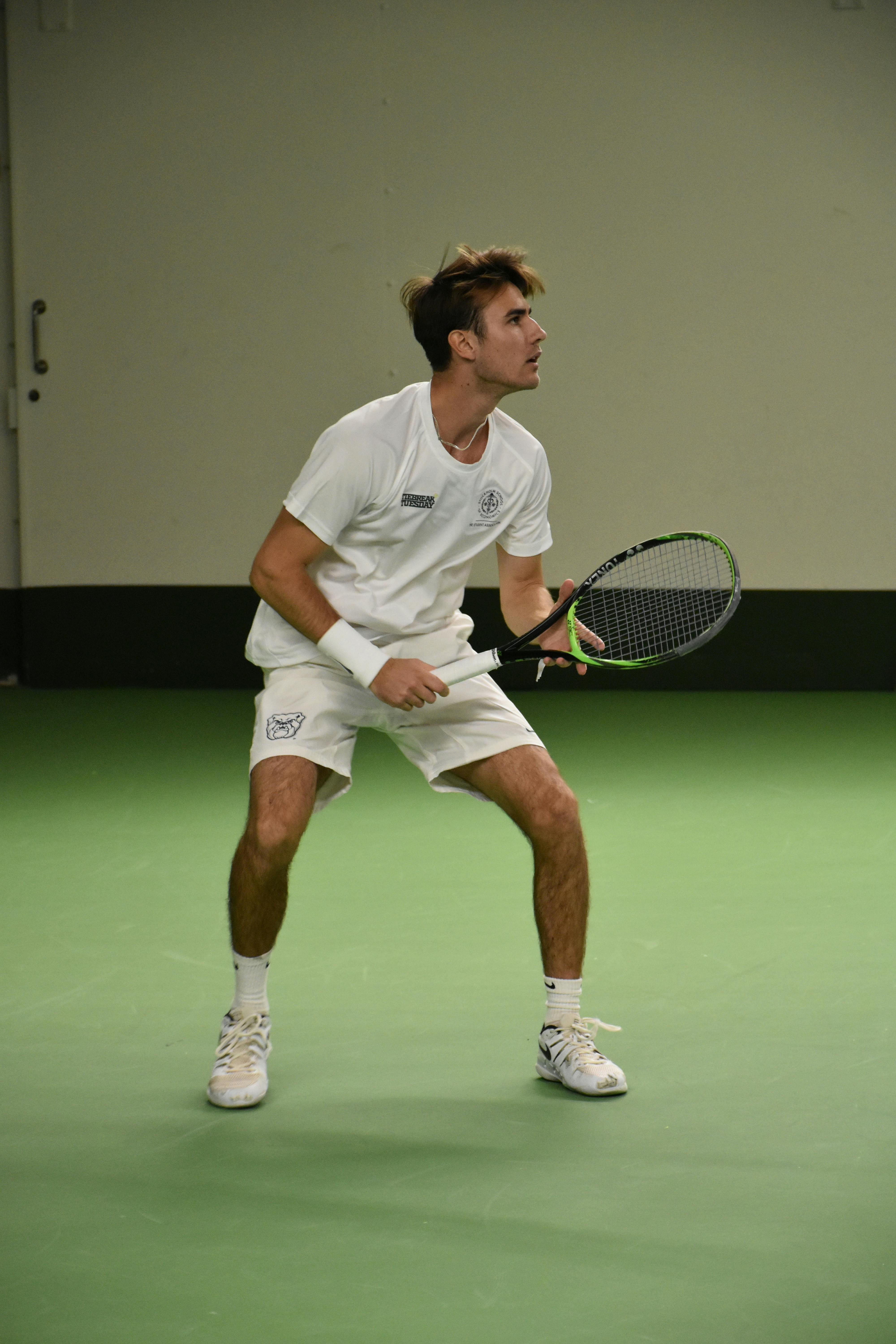 A male tennis player playing tennis