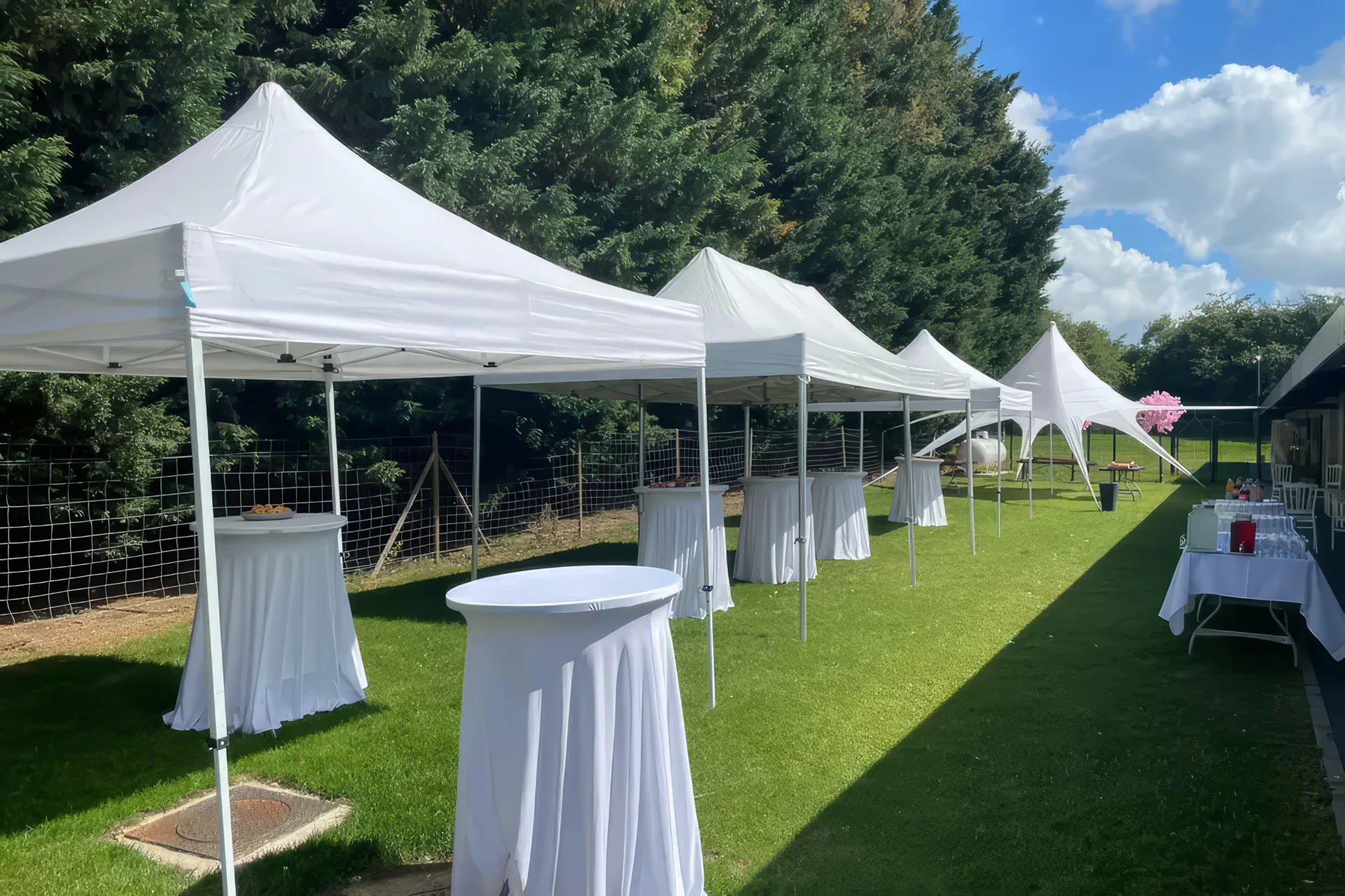 Modern indoor space with large glass doors, lush greenery, and a cozy seating area visible beyond.