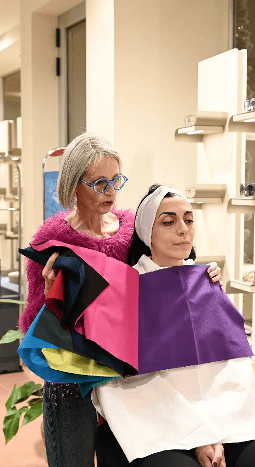 Cristina Notarangelo di Ottica Dentella ad Ancona durante una consulenza d’immagine personalizzata, mentre utilizza tessuti di colori differenti accanto a una cliente per valutare quali tonalità valorizzano maggiormente il viso. Il percorso di consulenza aiuta a scegliere l’occhiale considerando stile personale, colori, caratteristiche del volto e immagine complessiva, con l’obiettivo di individuare una montatura che non sia soltanto esteticamente adatta, ma realmente coerente con l’identità di chi la indossa.