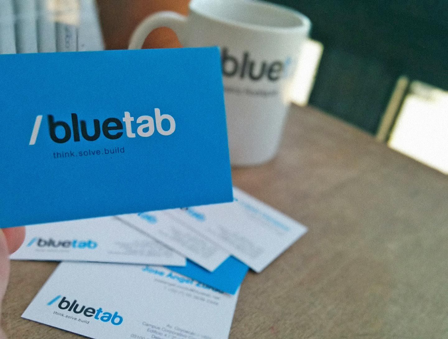 Tarjeta de presentación /bluetab y taza de café con logotipo de la empresa bluetab.