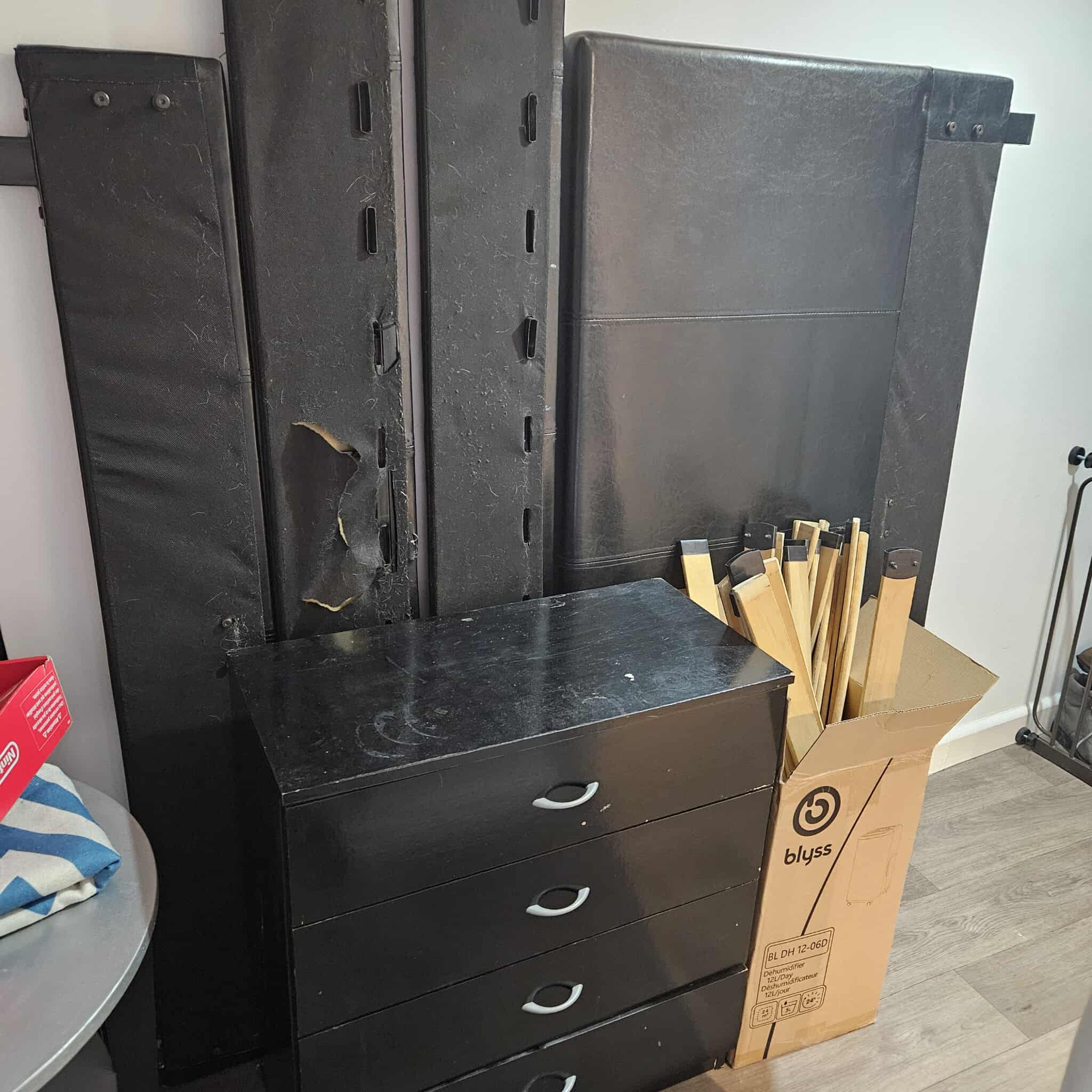 A collection of household items and wooden furniture prepared for an efficient property clearance service by the MovingOn team.