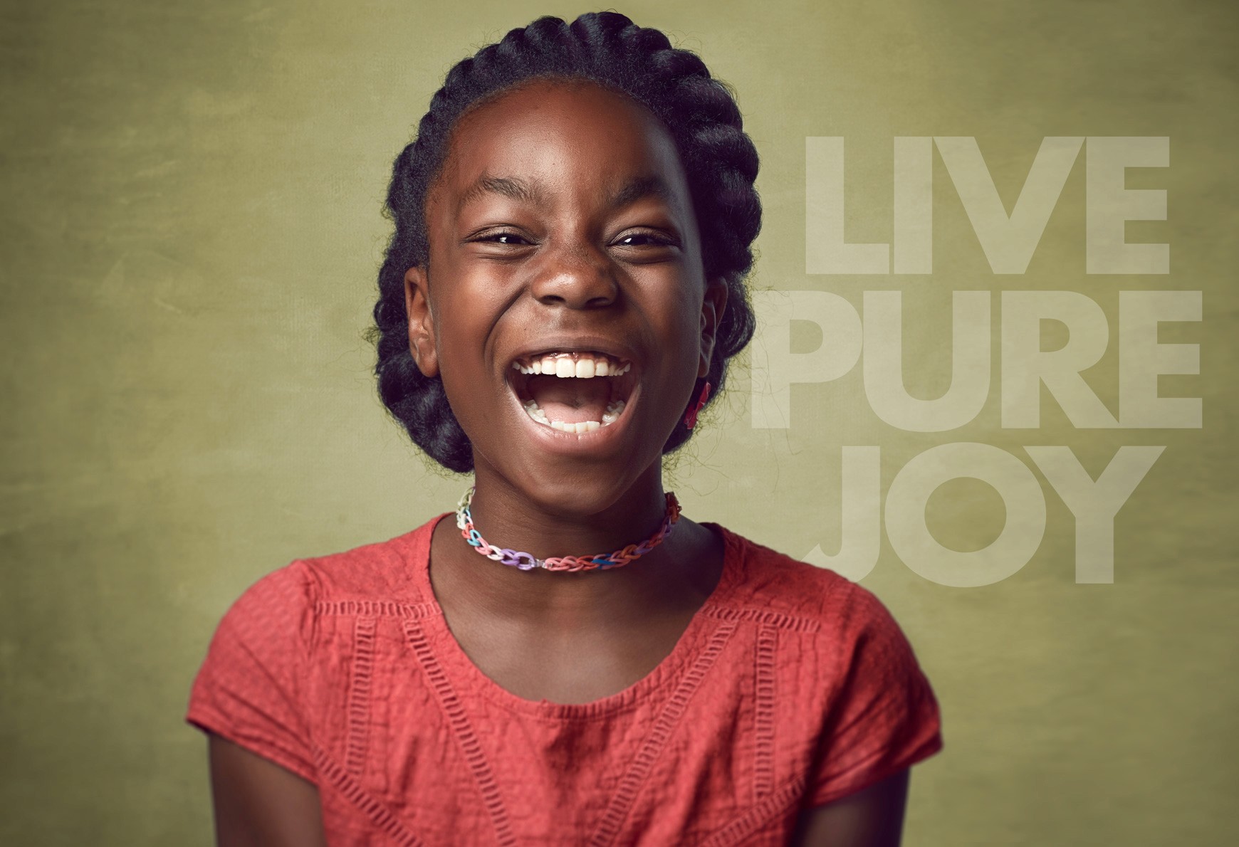 Joyful Black american female child wearinng a red shirt big teeth showing