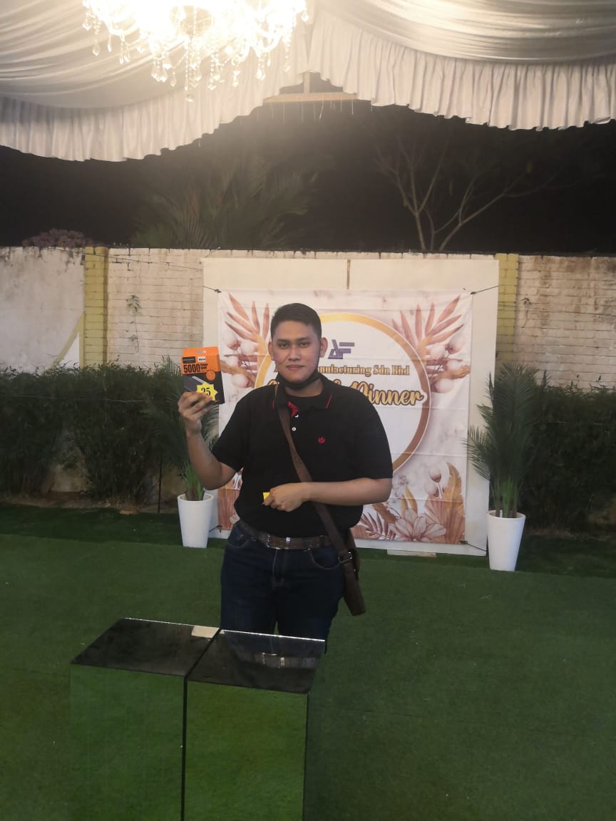 Employee holding a 5000mAh power bank prize at the Annual Dinner 2023 celebration.