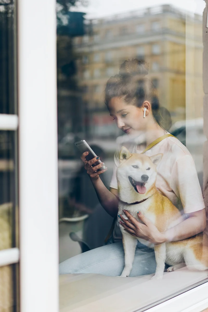 Customer sitting by a window with a small white dog