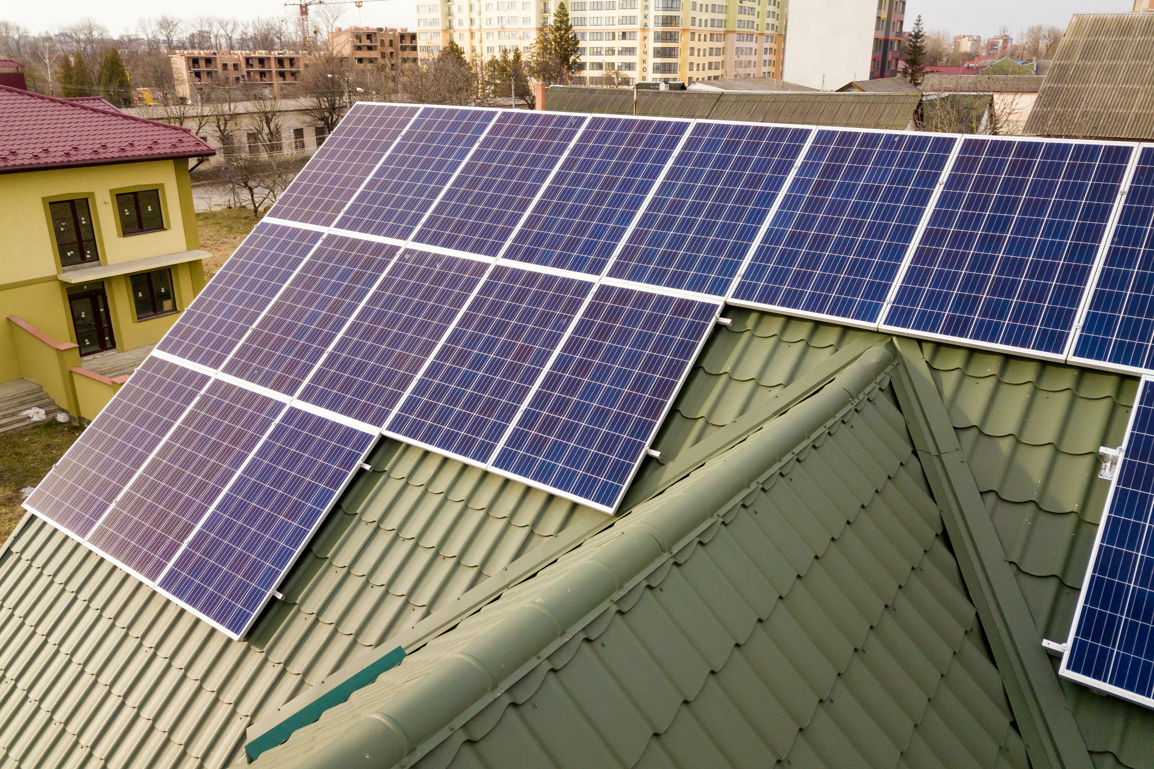 Solar Panele welche auf einem Haus mit einer Grünen Dach fassade installiert sind