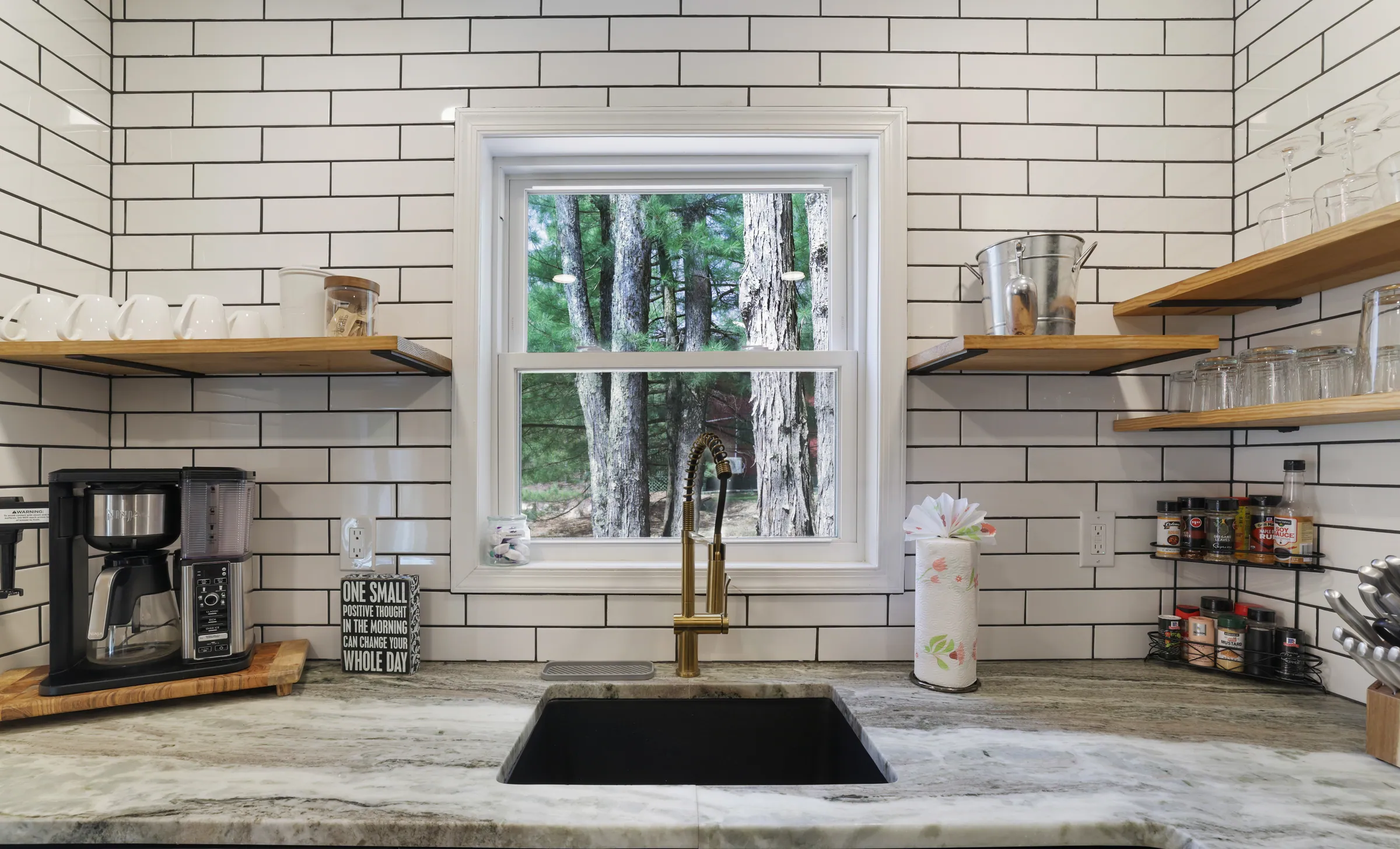 Kitchen sink with marble-look counters, open shelves and coffee bar at Divine on Lupine