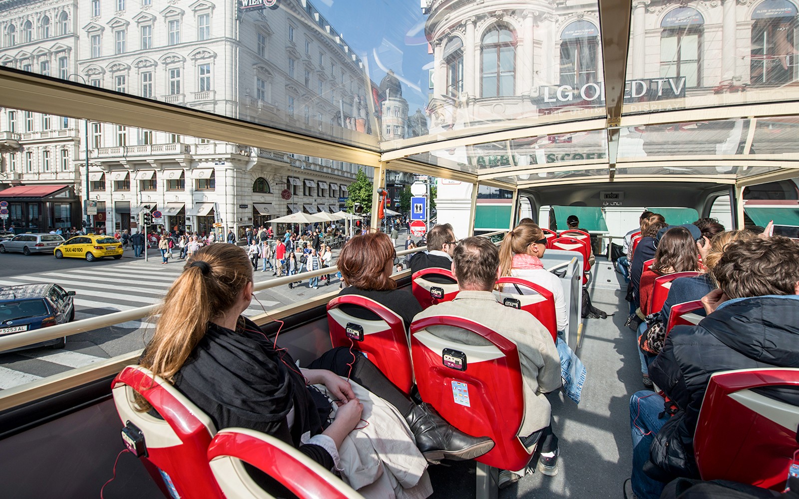 Passengers on a Vienna Hop-On Hop-Off bus touring city streets.