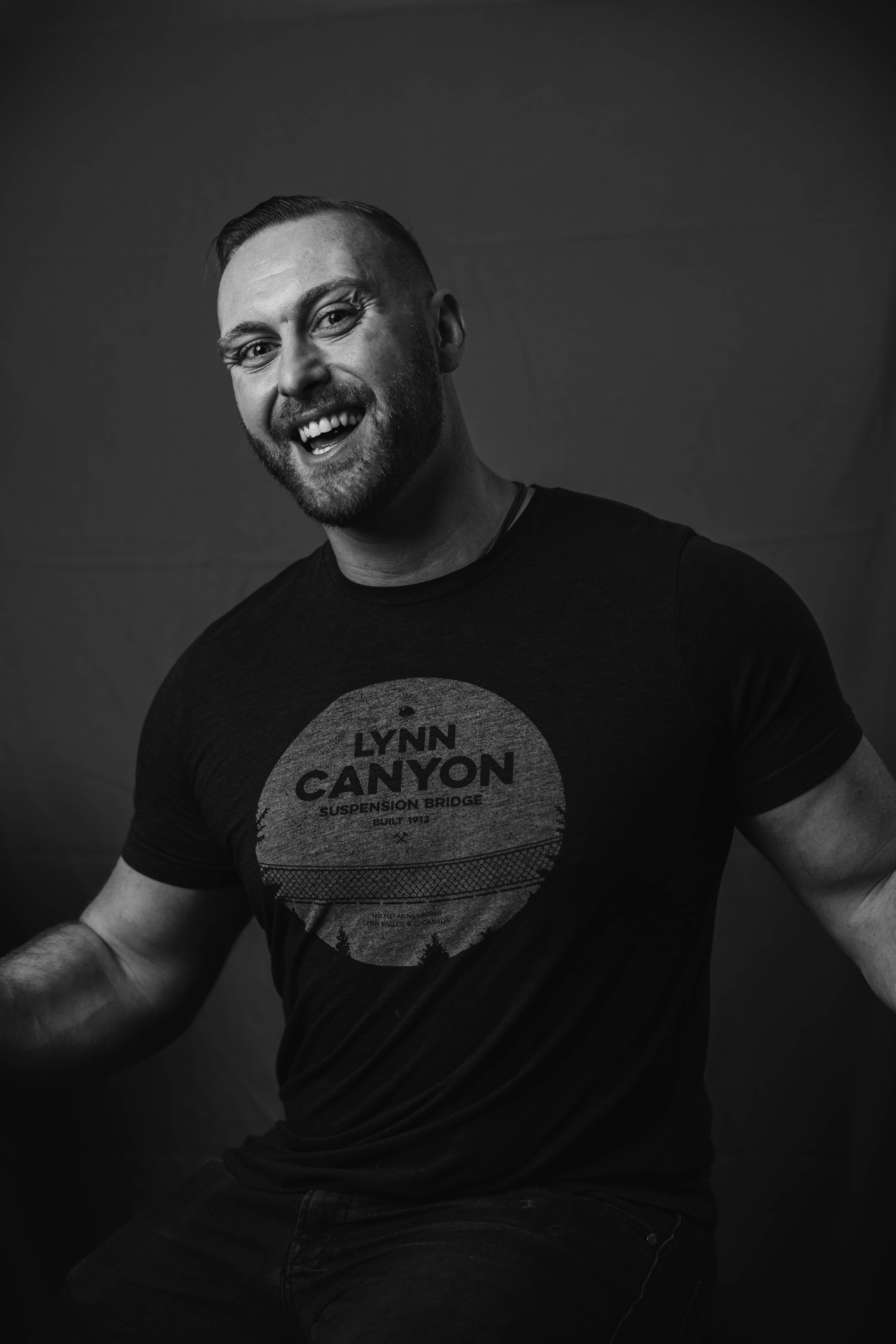 A person with shoulder-length blonde hair wearing a black newsboy cap and a black sweater.