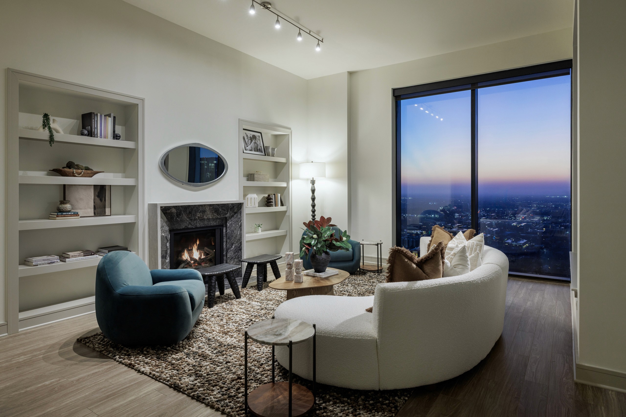 Modern living room with curved sofa and city view.