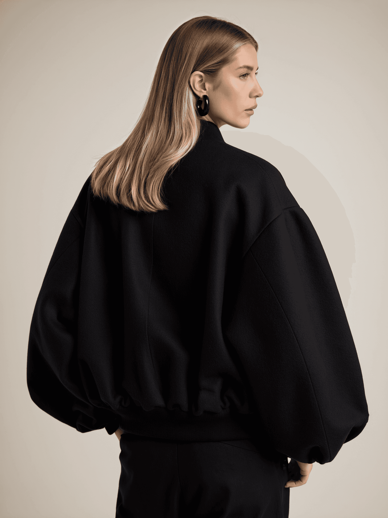 A view of a studio interior with modern decor, featuring large windows that offer a glimpse of lush greenery outside