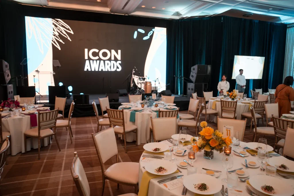 Banquet tables facing a stage displaying “Icon Awards”