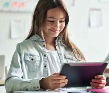 aluna lendo em tablet para recuperar defasagem escolar