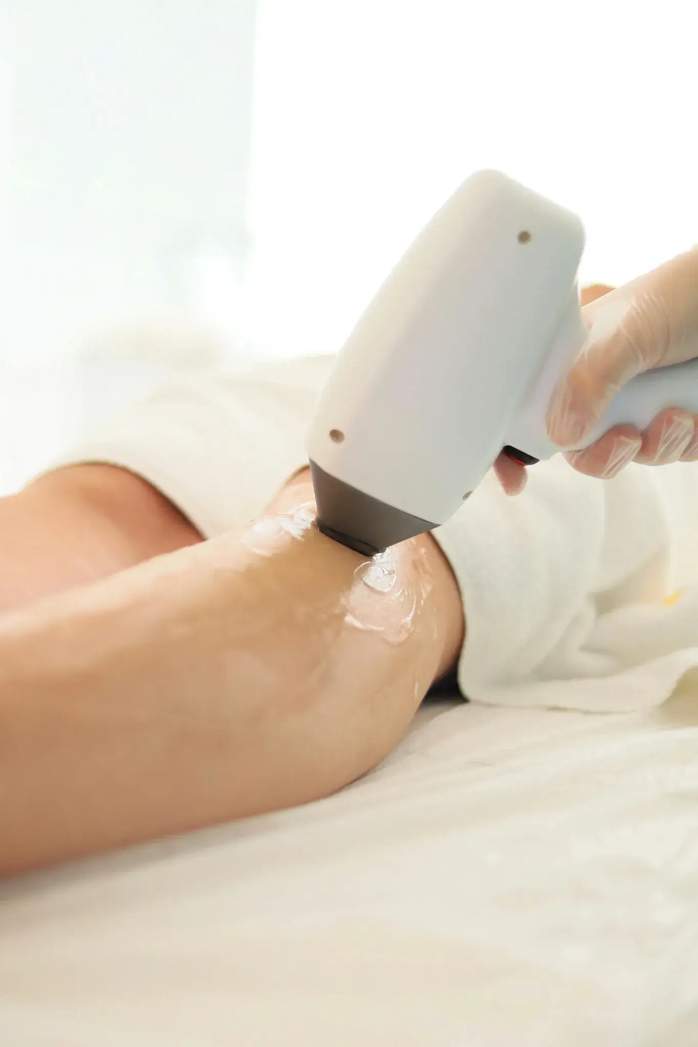 Laser hair removal treatment being performed on a client’s leg for long-term hair reduction and smoother skin.
