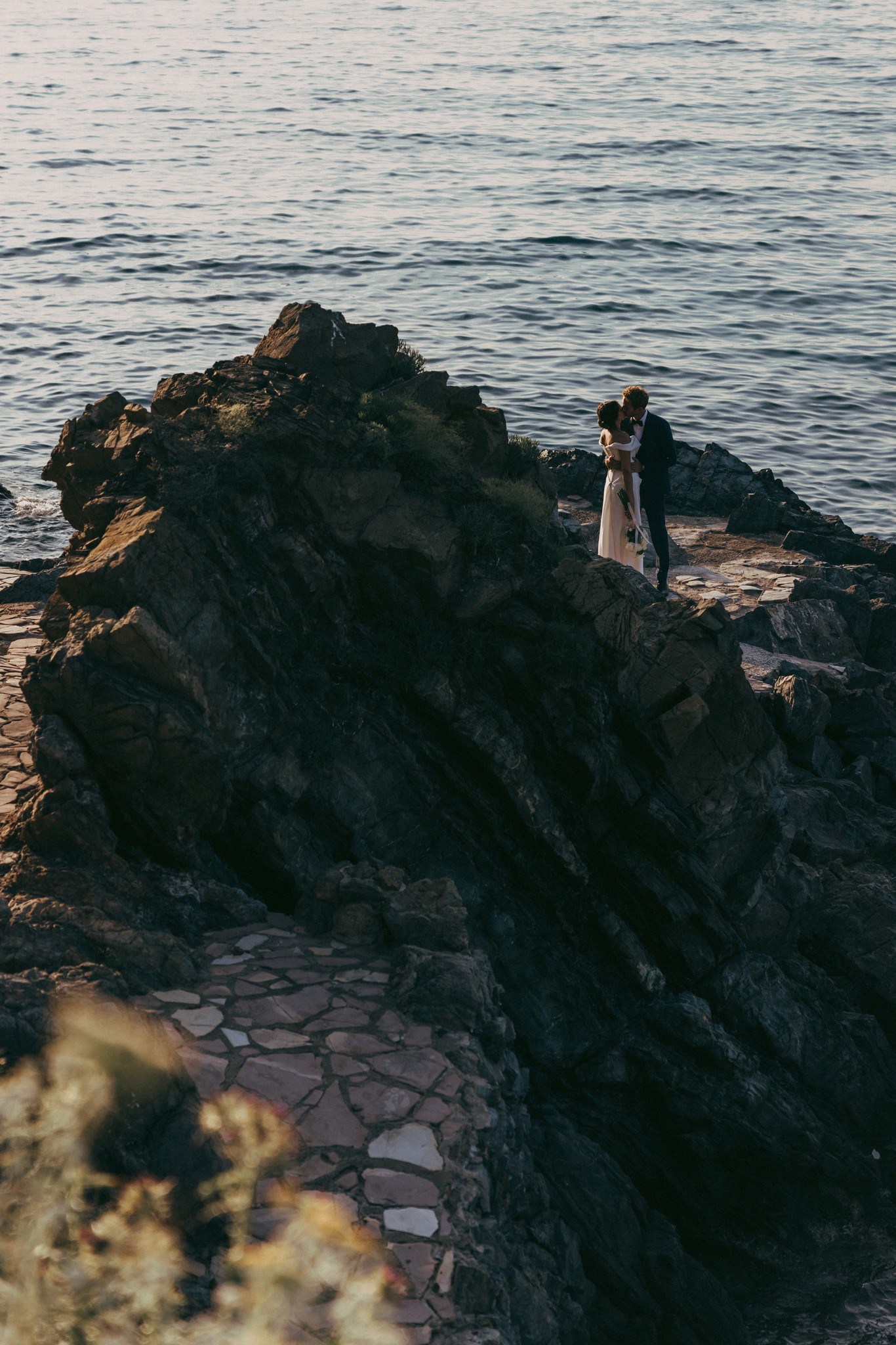 Sposi su scogliera rocciosa al tramonto, Isola d'Elba, reportage di matrimonio Fotolize