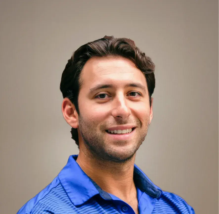 Man in blue polo shirt smiling.