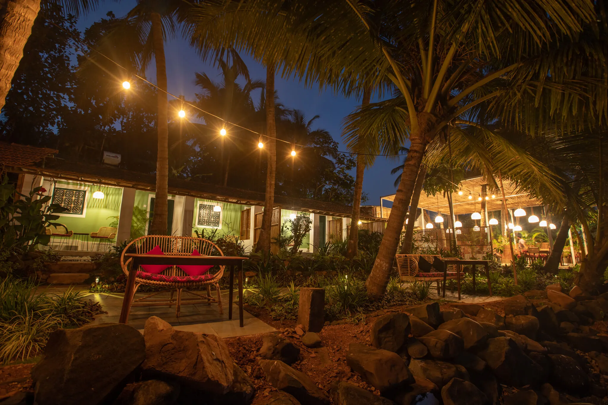 String lights over the seafront garden at night, Casa Jaali