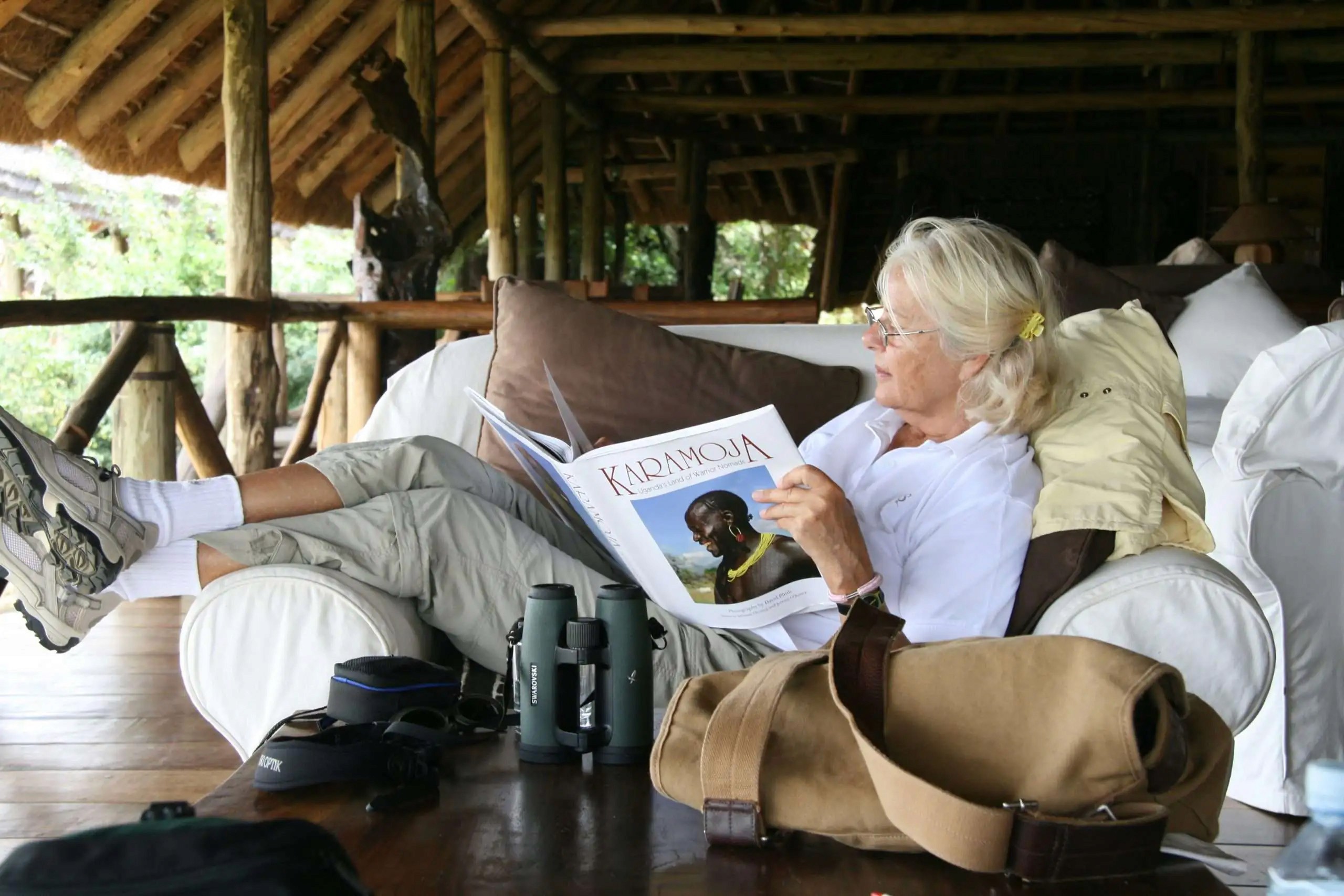 A tourist unwinds at the lodge while reading about the people of Karamoja