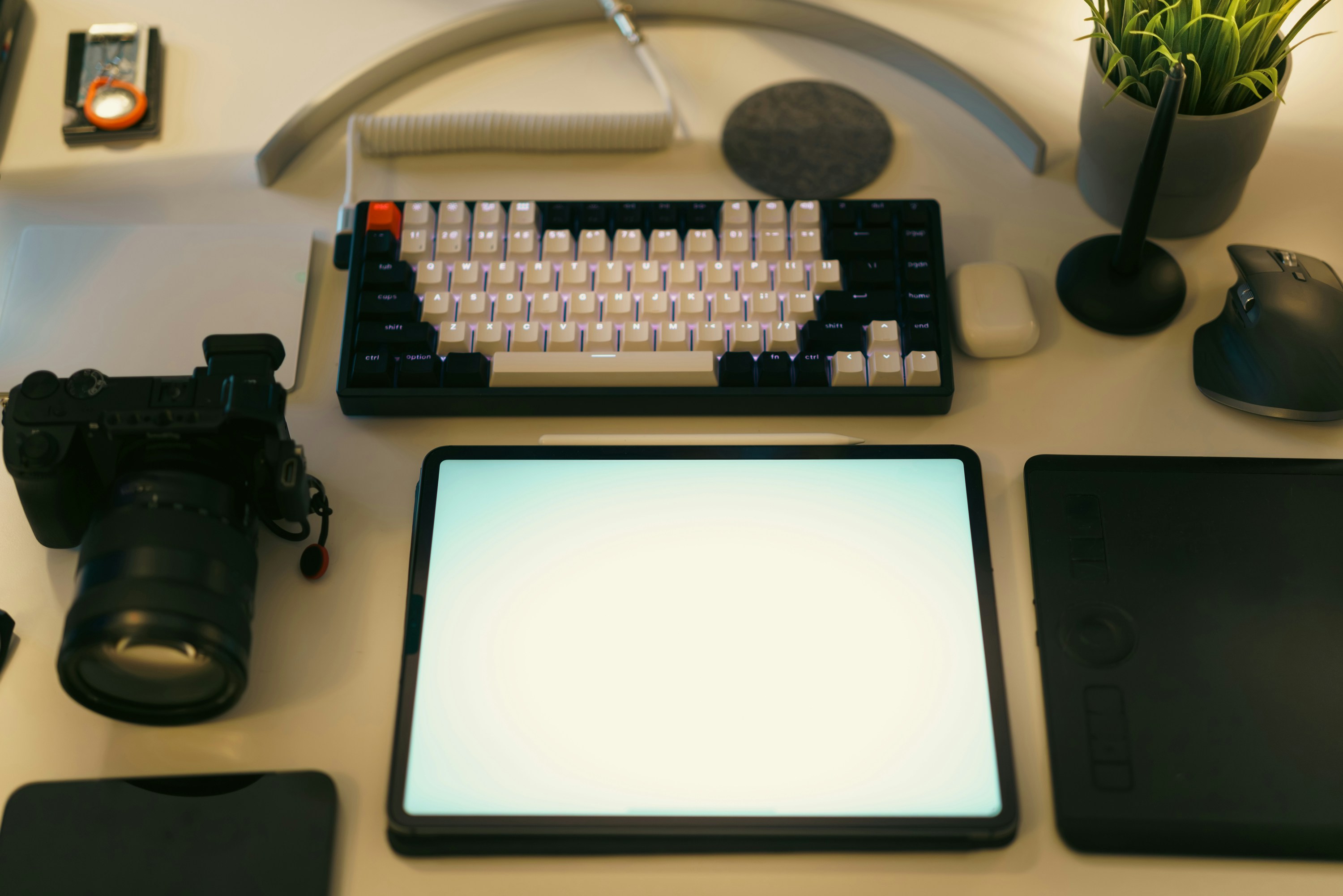 Desk setup with digital camera, keyboard, and other accessories.