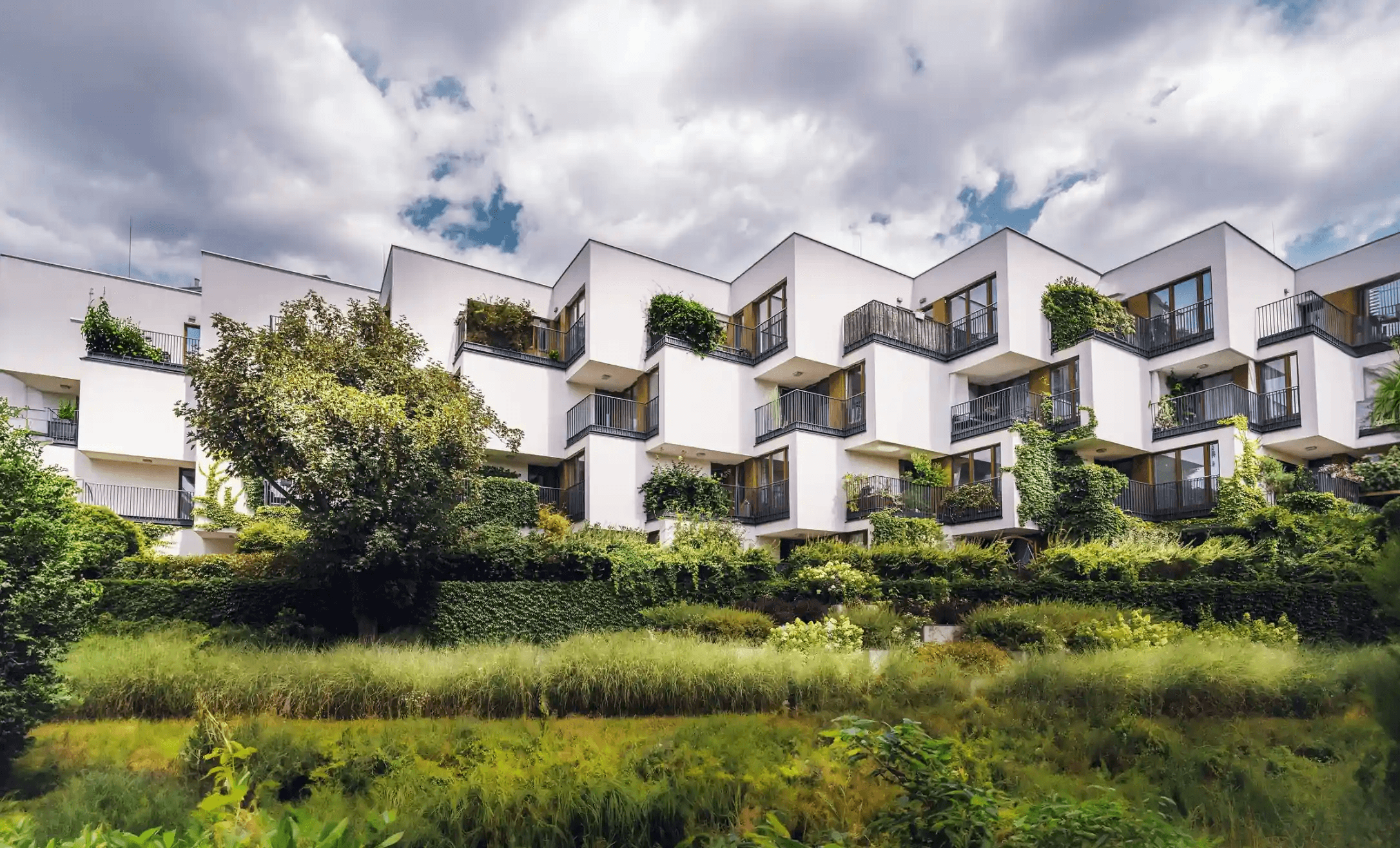 Moderne Gebäudeanlage mit begrünten Terrassen und vielen Bäumen