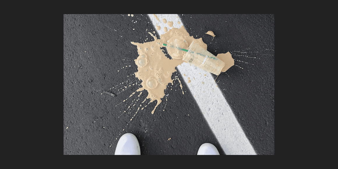 Close-up of a burst food packet splattered on pavement, viewed from above