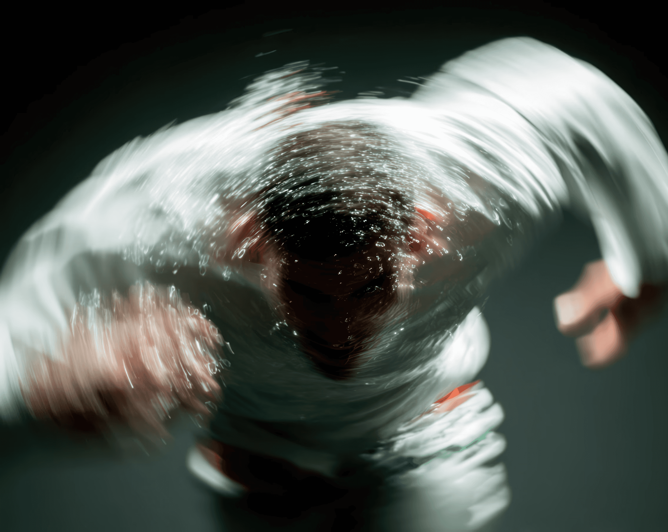 Runner in a green jacket leaning forward in dynamic motion blur