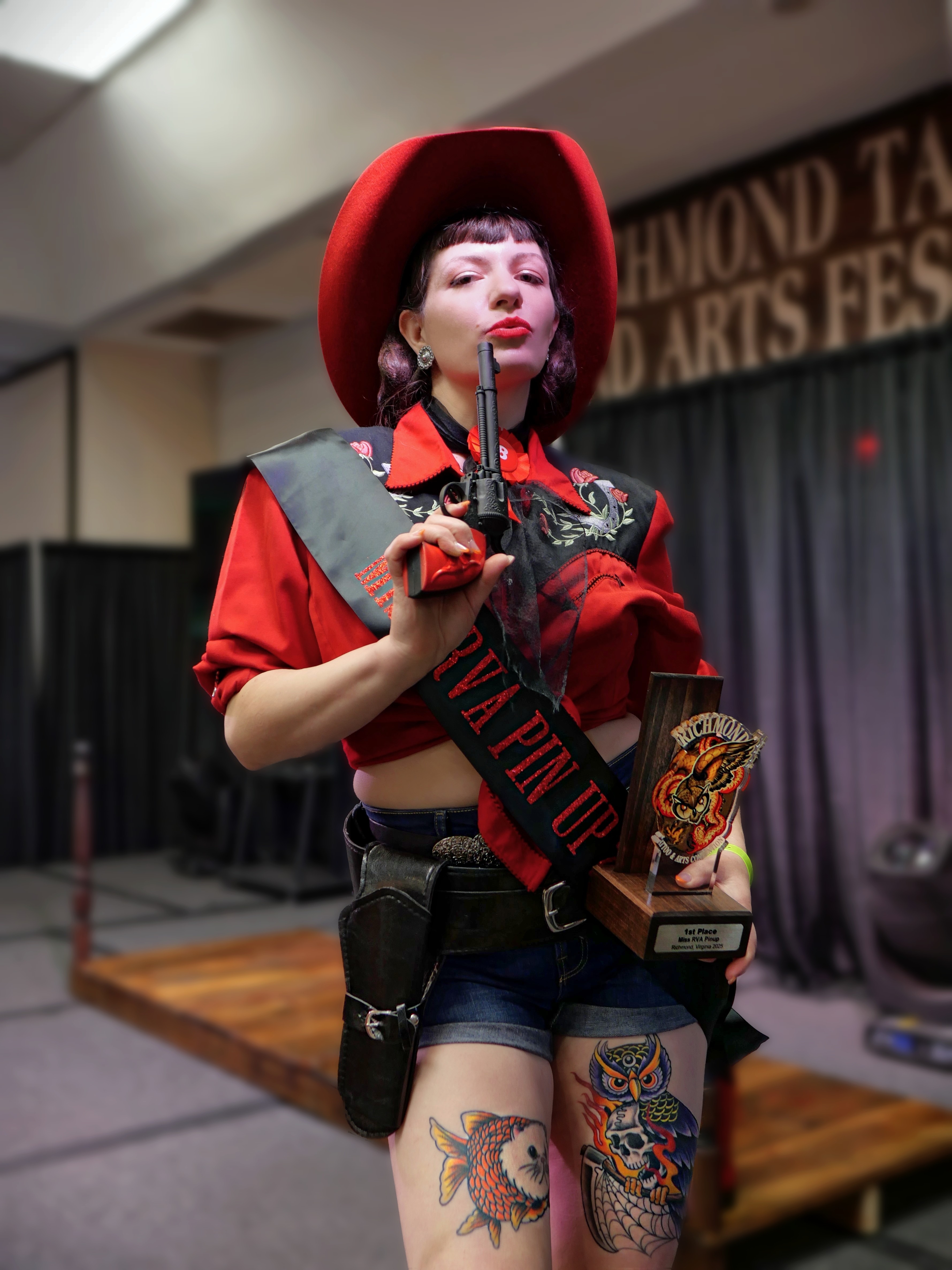 Photo of pinup competition winner kissing a trophy hosted by babygirl vintage at the richmond tattoo and arts convention