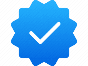 A blue verification badge icon featuring a white checkmark centered within a scalloped, circular background, symbolizing authenticity and verification.