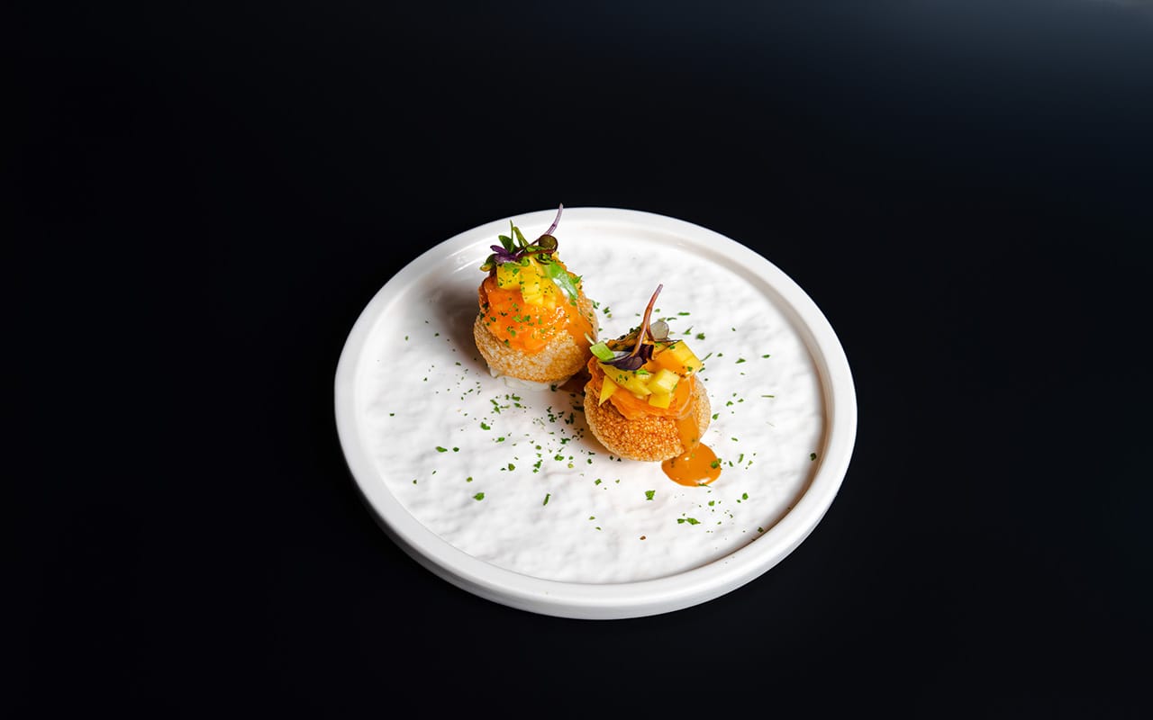 a black plate topped with sushi and chopsticks