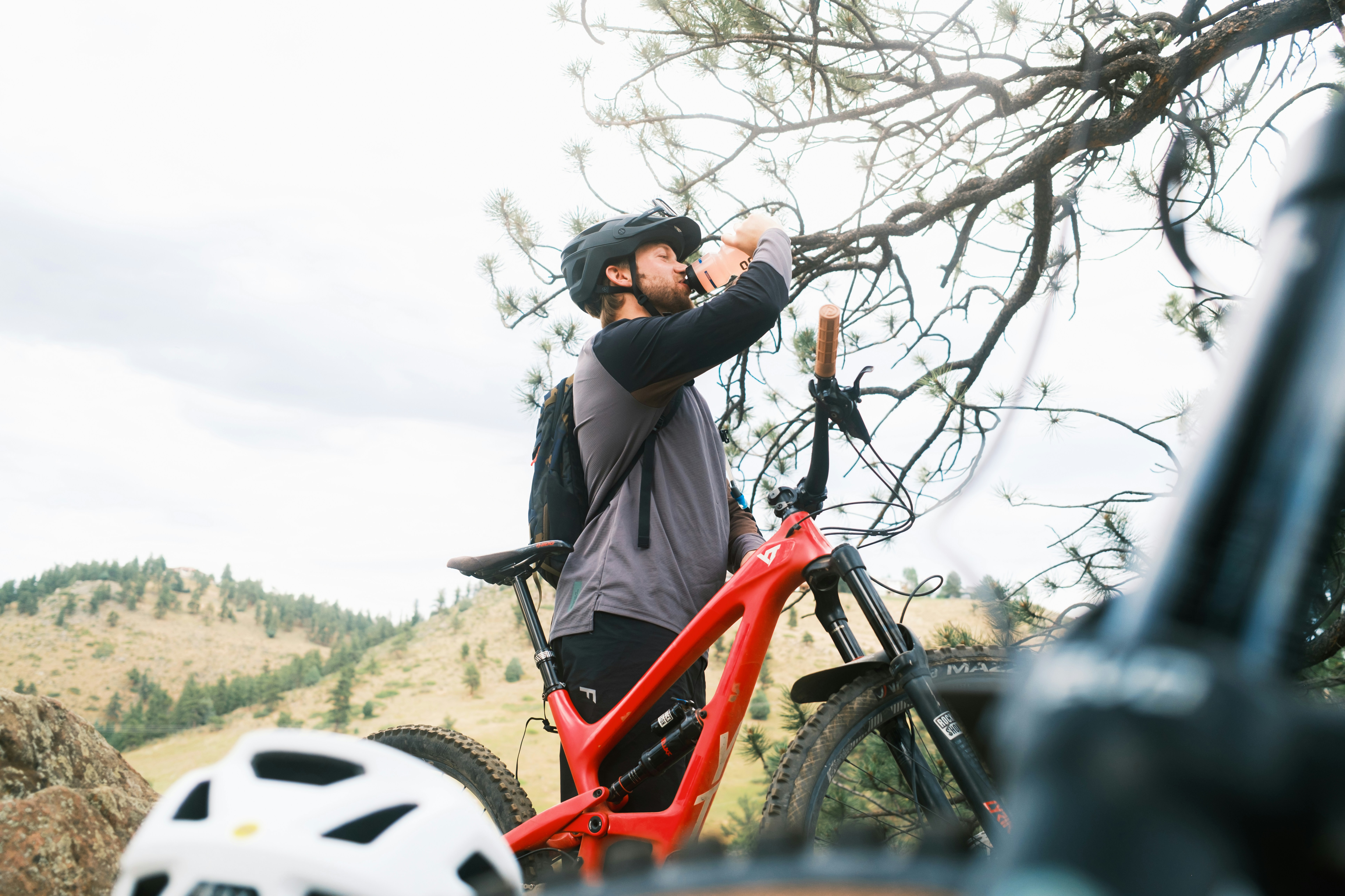 Mountain biker drinking water next to bicycle
