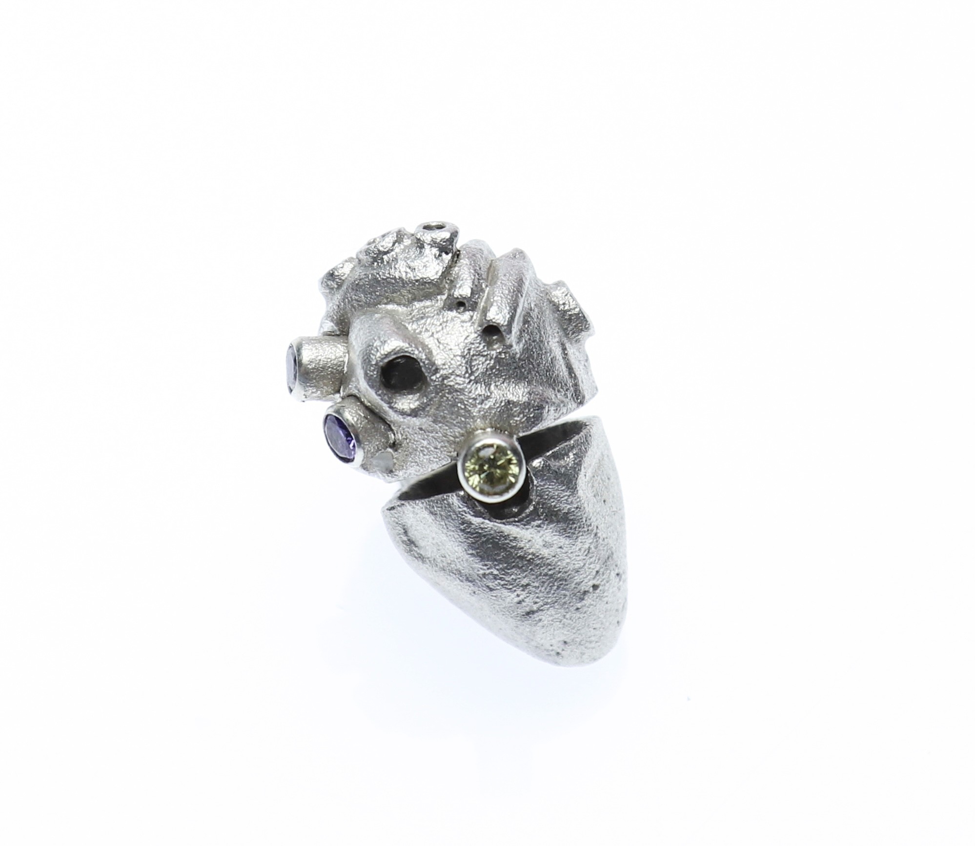 Heart within pendant by Yuxin Song, casted sterling silver with CZ stone. Anatomical heart containing a cartoon heart, 3 x 1.5 x 1.5cm, 2022. Exploring emotional complexity through jewelry art.