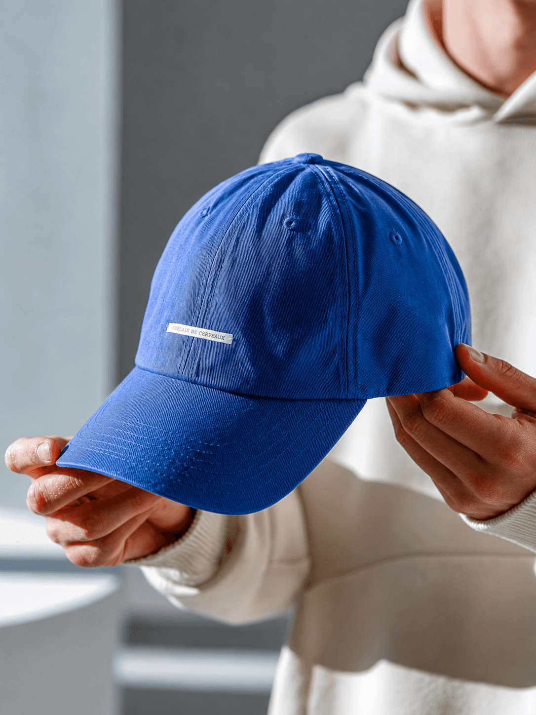 Blue cotton baseball cap with small front label shown in a lifestyle product photo