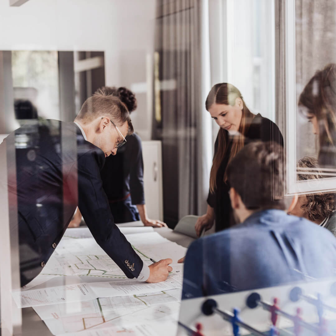 Professionelle Gastronomie- & Interieur-Fotografie: Gemütliche Lounge-Ecke mit rotem Sessel und beleuchteter Wein-Präsentation, inszeniert mit warmem Ambient-Licht und Fokus auf Design-Details.