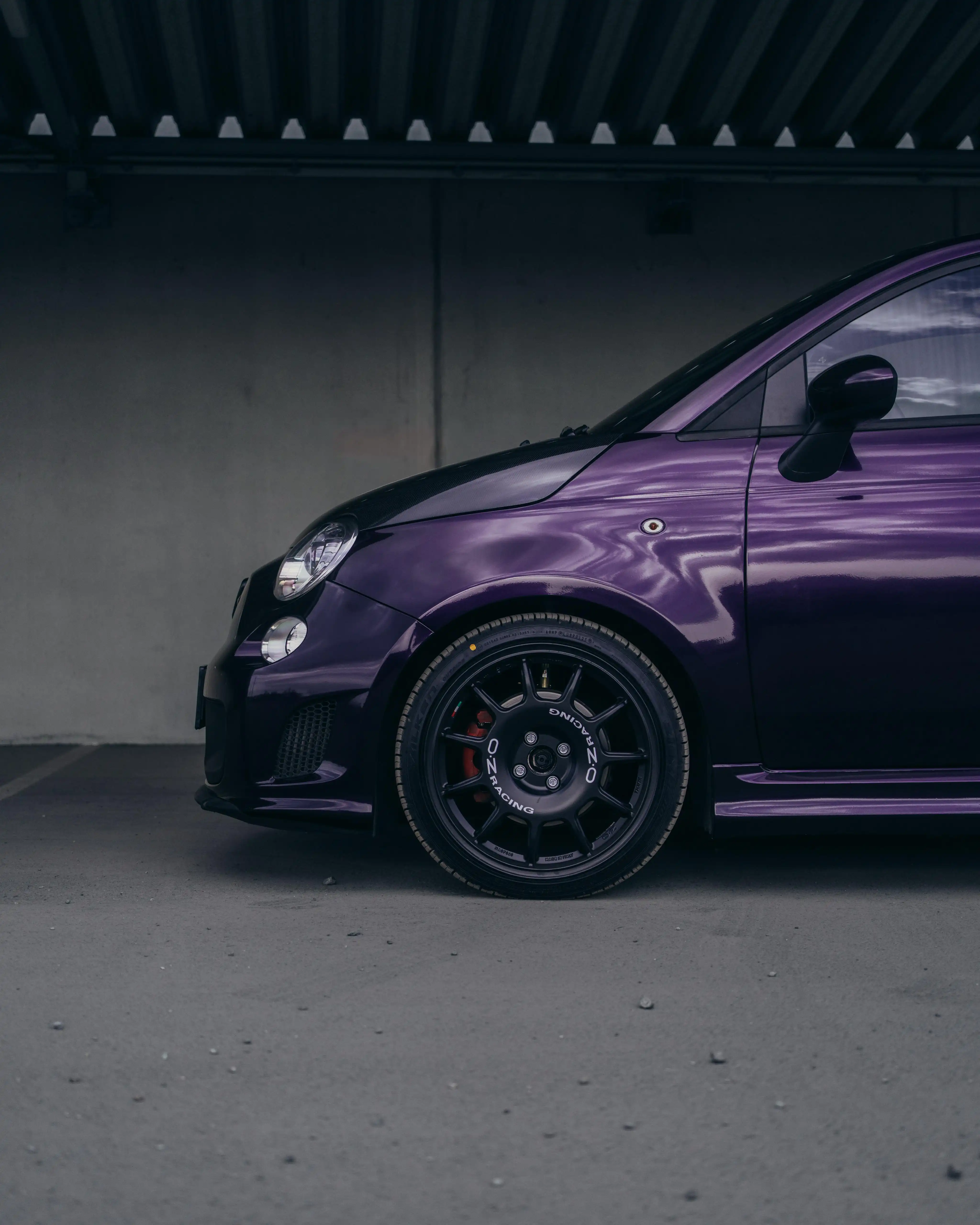 Seitenaufnahme des Fiat Abarth 500, Fokus auf die Kotflügel-Vollfolierung in Dark Purple von Laura Sommer