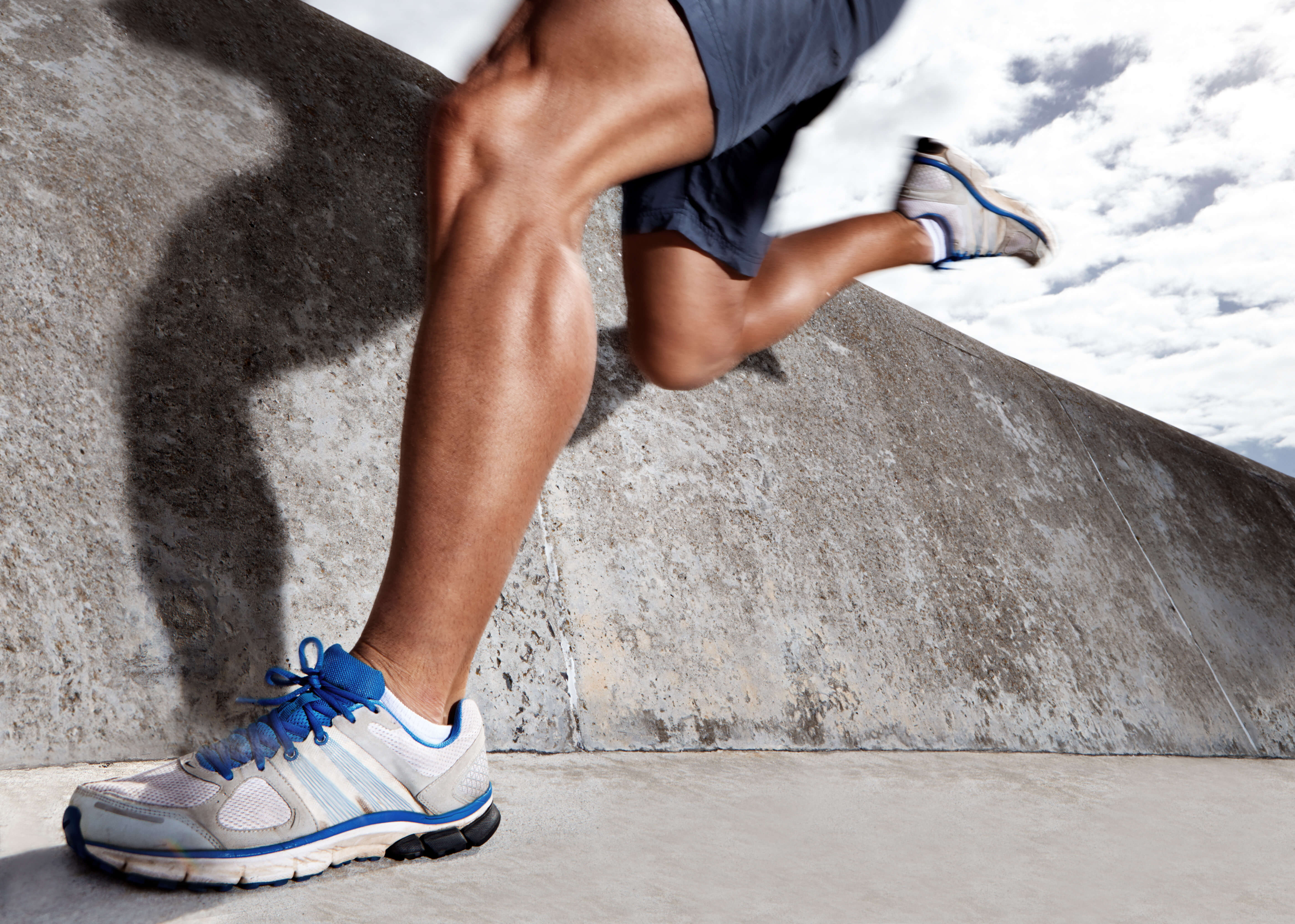 A powerful close-up of a runner’s legs mid-stride, symbolizing endurance.