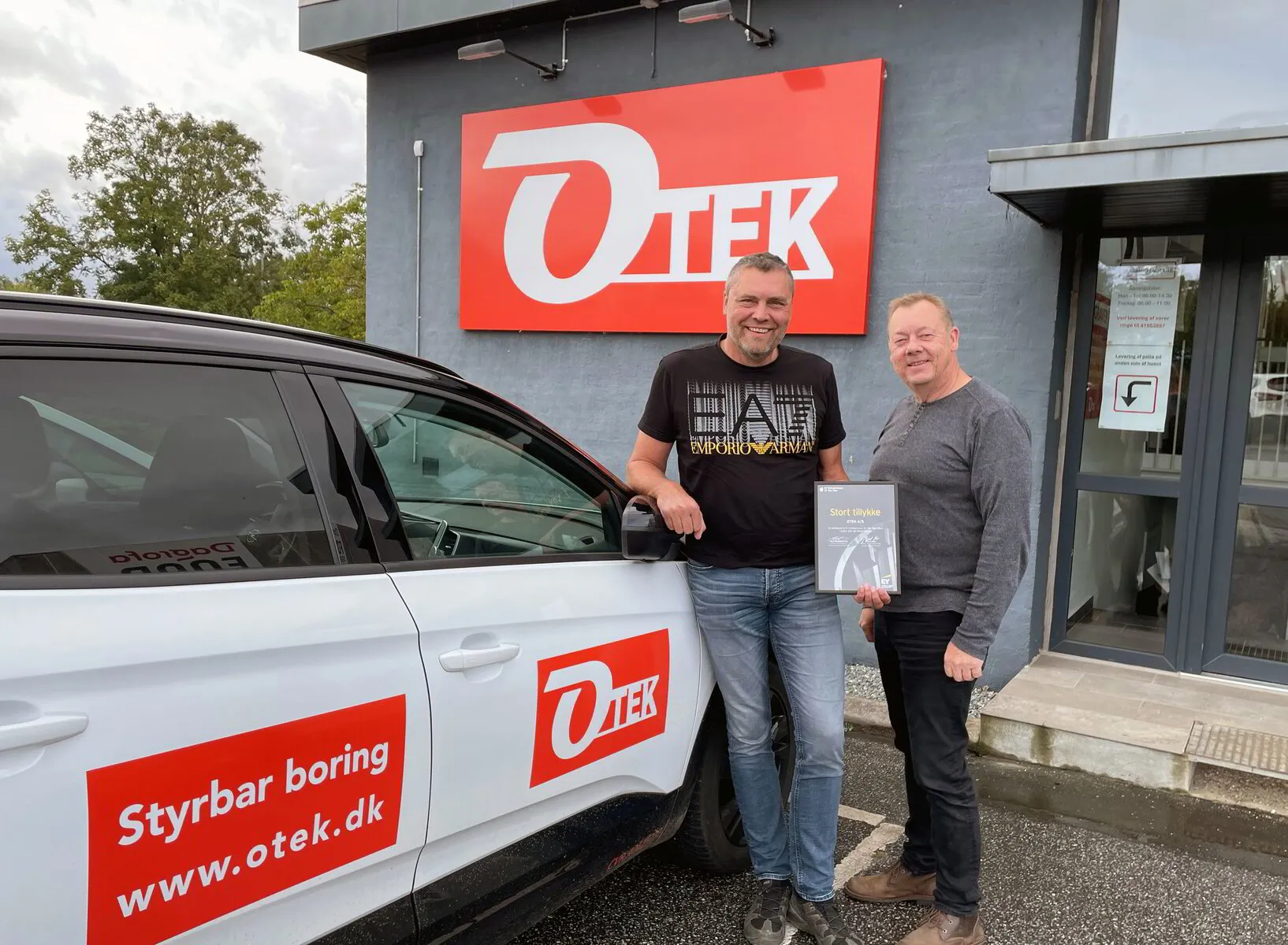 otek direktører foran bygning