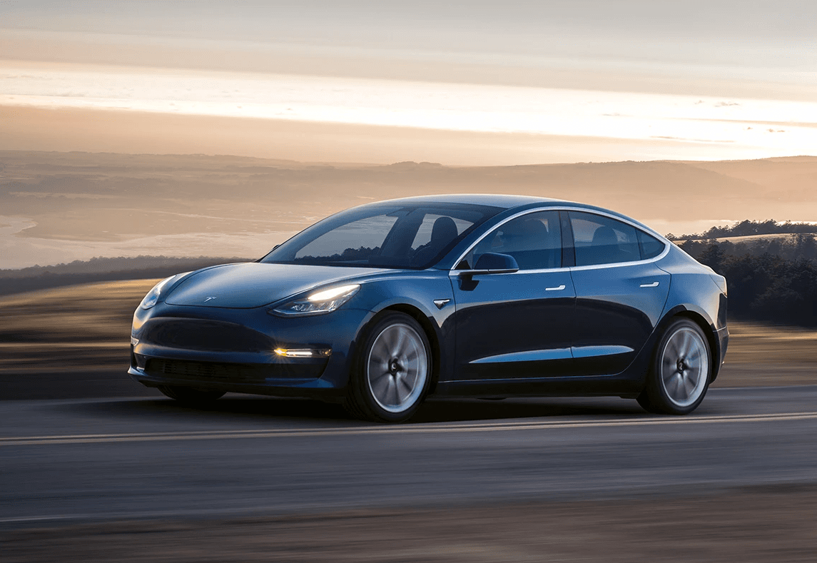 Tesla Model 3 bleue sur route ouverte, berline électrique en conduite dans une lumière de fin de journée